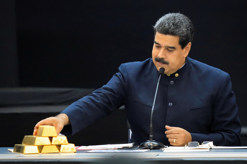 Venezuelan President Nicolás Maduro touches a gold bar as he speaks with economic officials at Miraflores Palace in Caracas in March. (Marco Bello/Reuters)