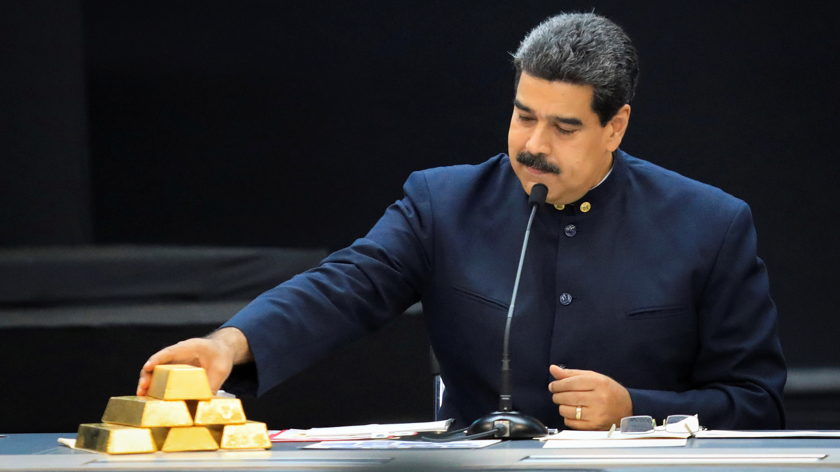 Venezuelan President Nicolás Maduro touches a gold bar as he speaks with economic officials at Miraflores Palace in Caracas in March.