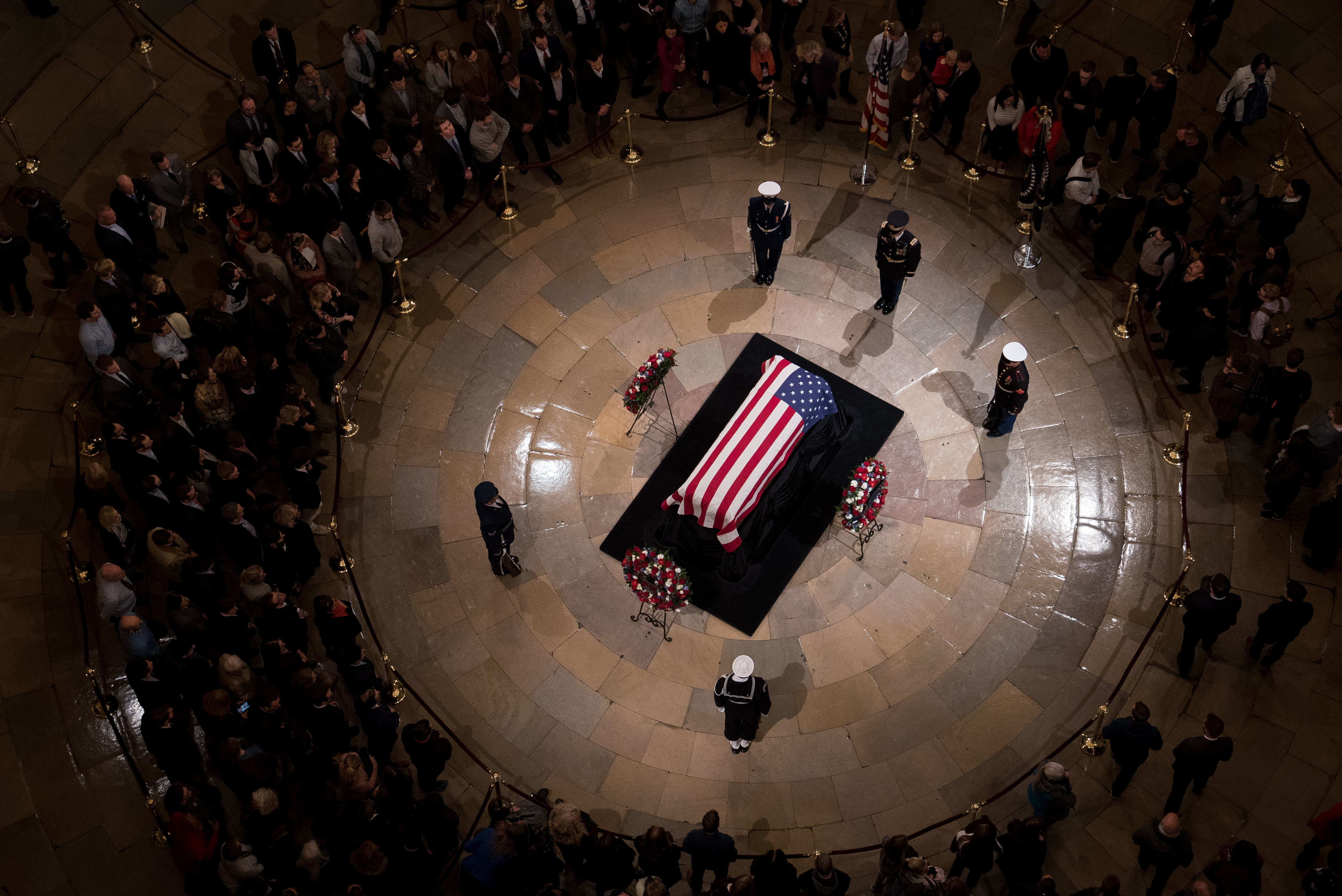 Members of the public view the casket containing former President George H.W. Bush's remains as he lies in state in the U.S. Capitol Rotunda on Monday night. (NPR)