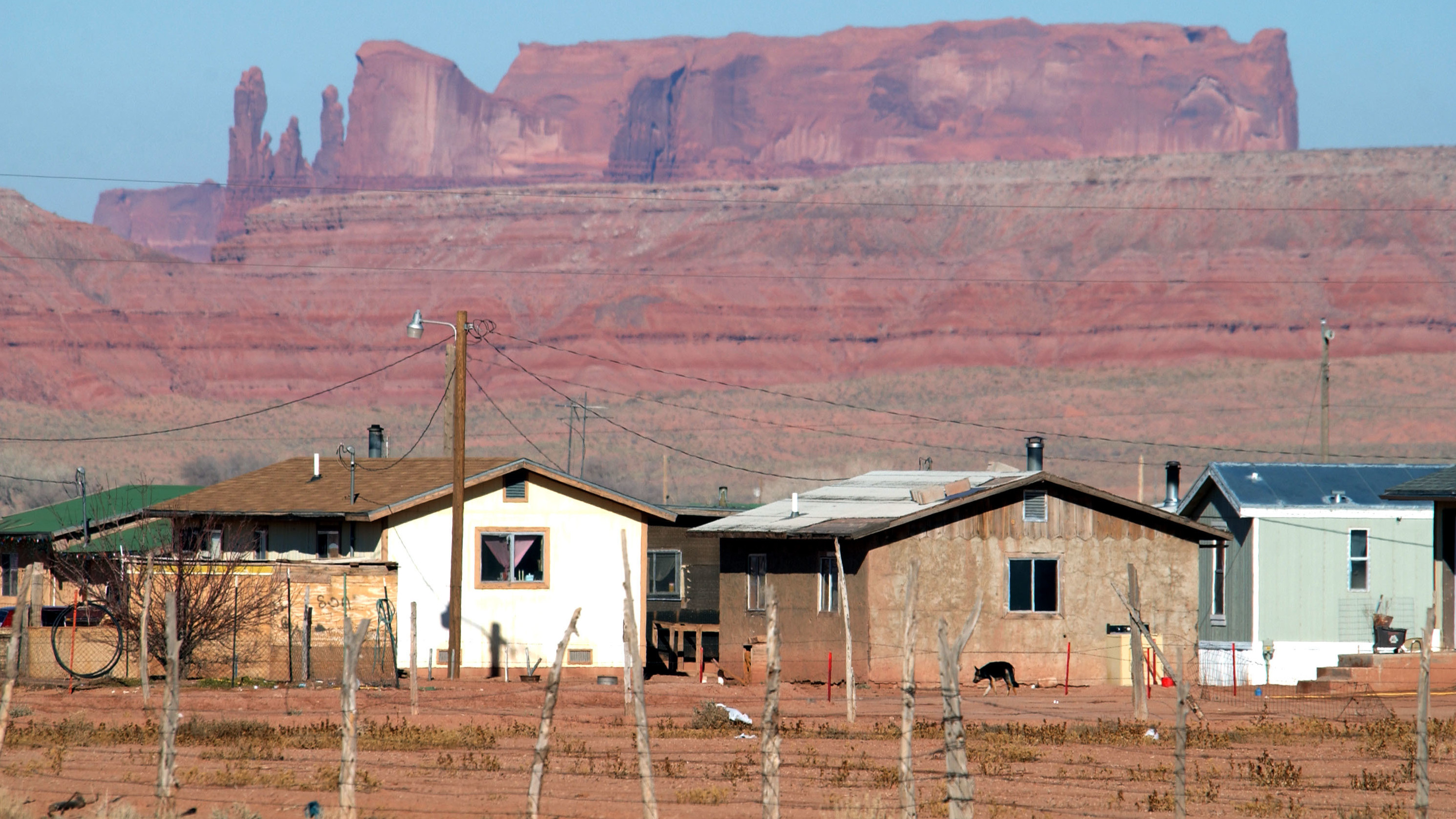 Houses on the Navajo Nation sit near sandstone cliffs north of Many Farms, Ariz. New Census Bureau estimates show a low rate of high-speed internet access among Native Americans who live on tribal land.