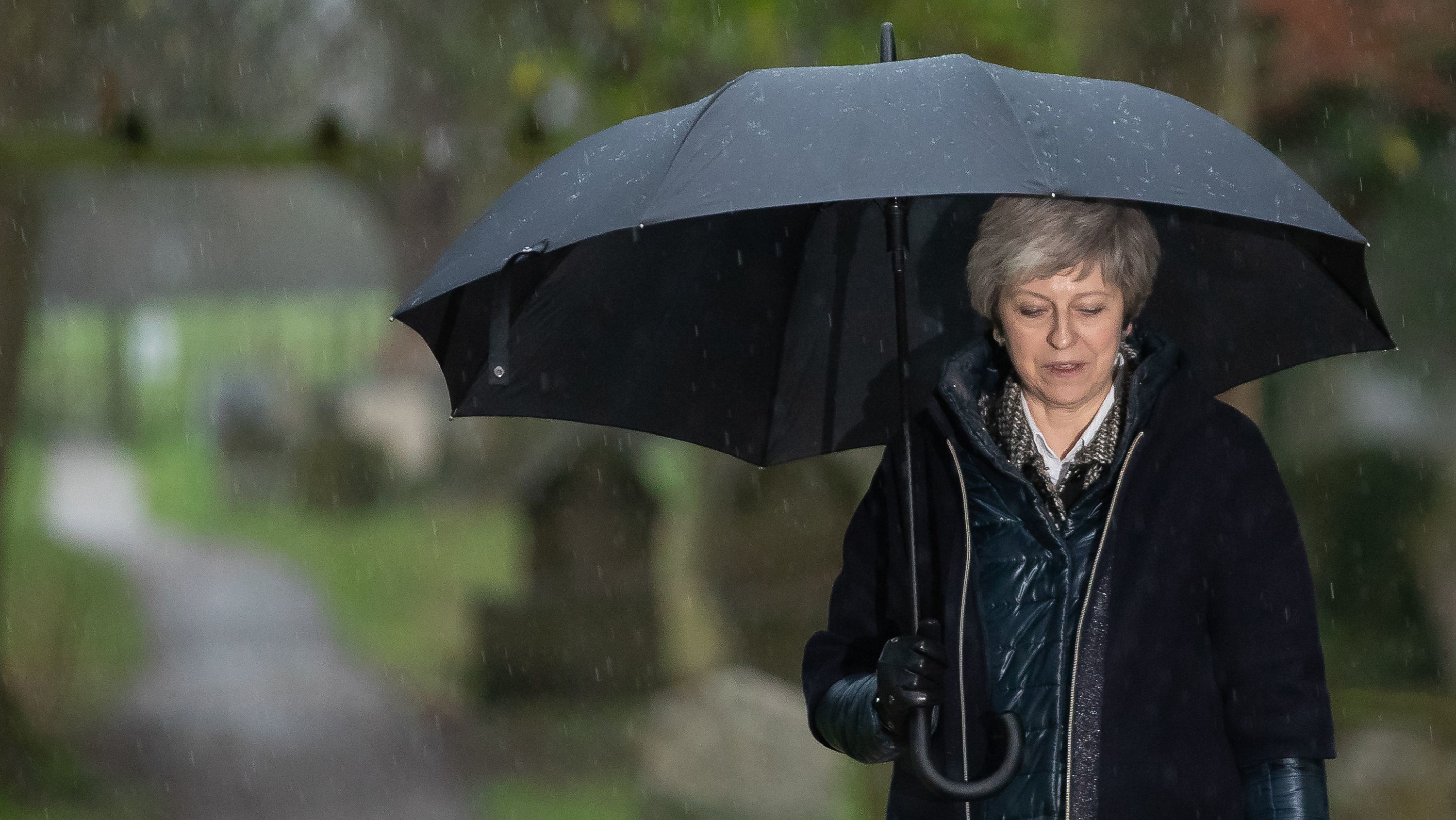 British Prime Minister Theresa May leaves a church service west of London in Sunday's pouring rain.