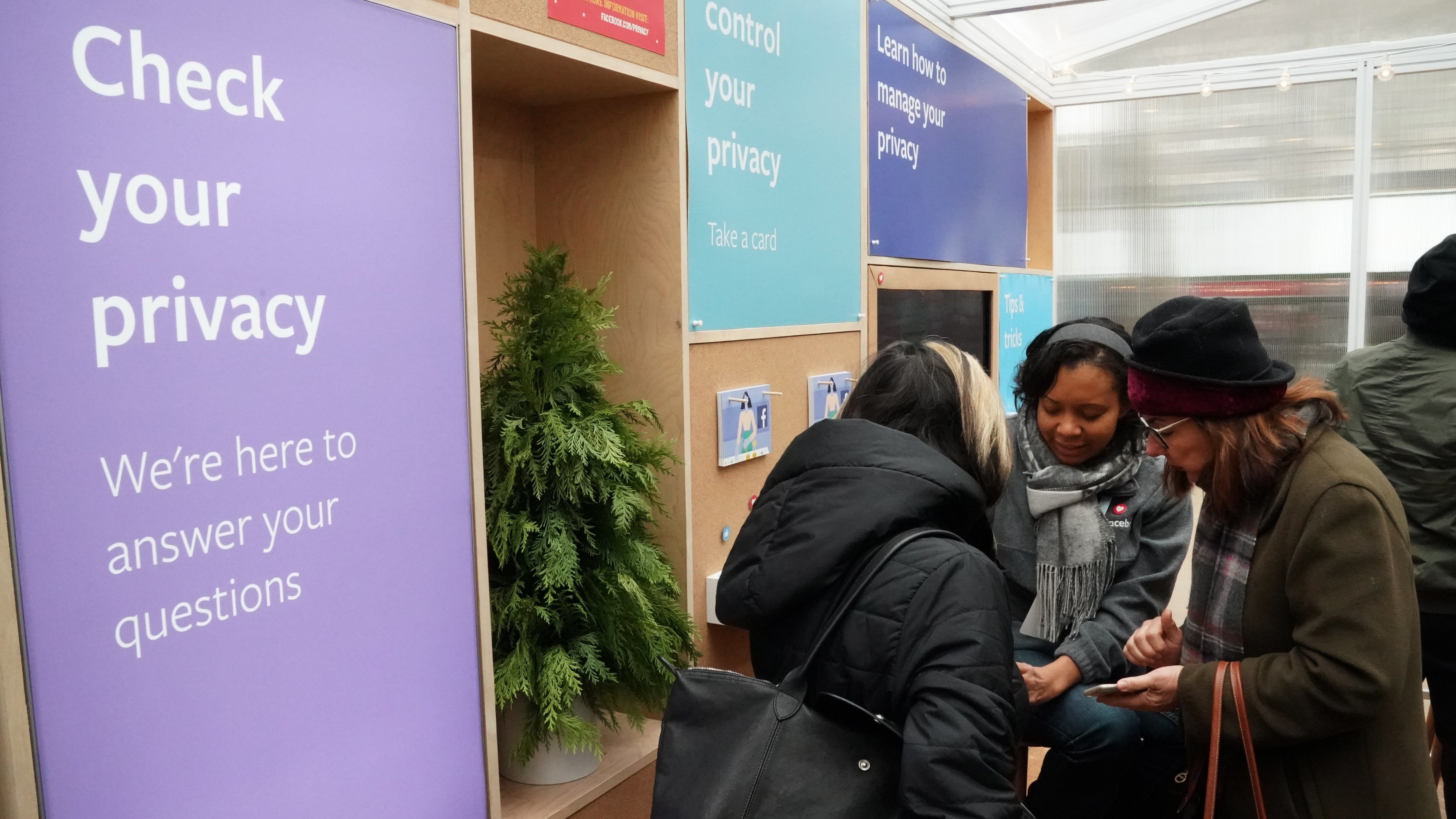 Facebook employees talk to visitors at a one-day Facebook pop-up kiosk in Bryant Park in New York City on Thursday. The company was fielding questions about its data-sharing practices and teaching users how to understand its new privacy controls. The next day, Facebook announced that a "bug" that had inappropriately shared users