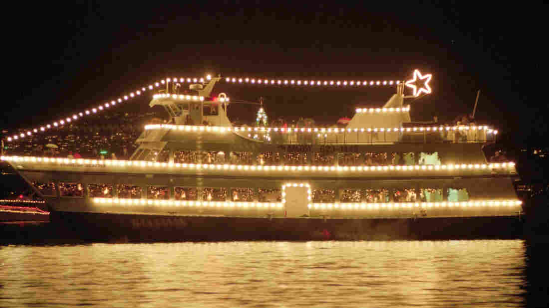 The small Argosy cruise ship Spirit of Seattle dresses up with Christmas lights and carries passengers on a Christmas caroling cruise around Lake Washington from Seattle.