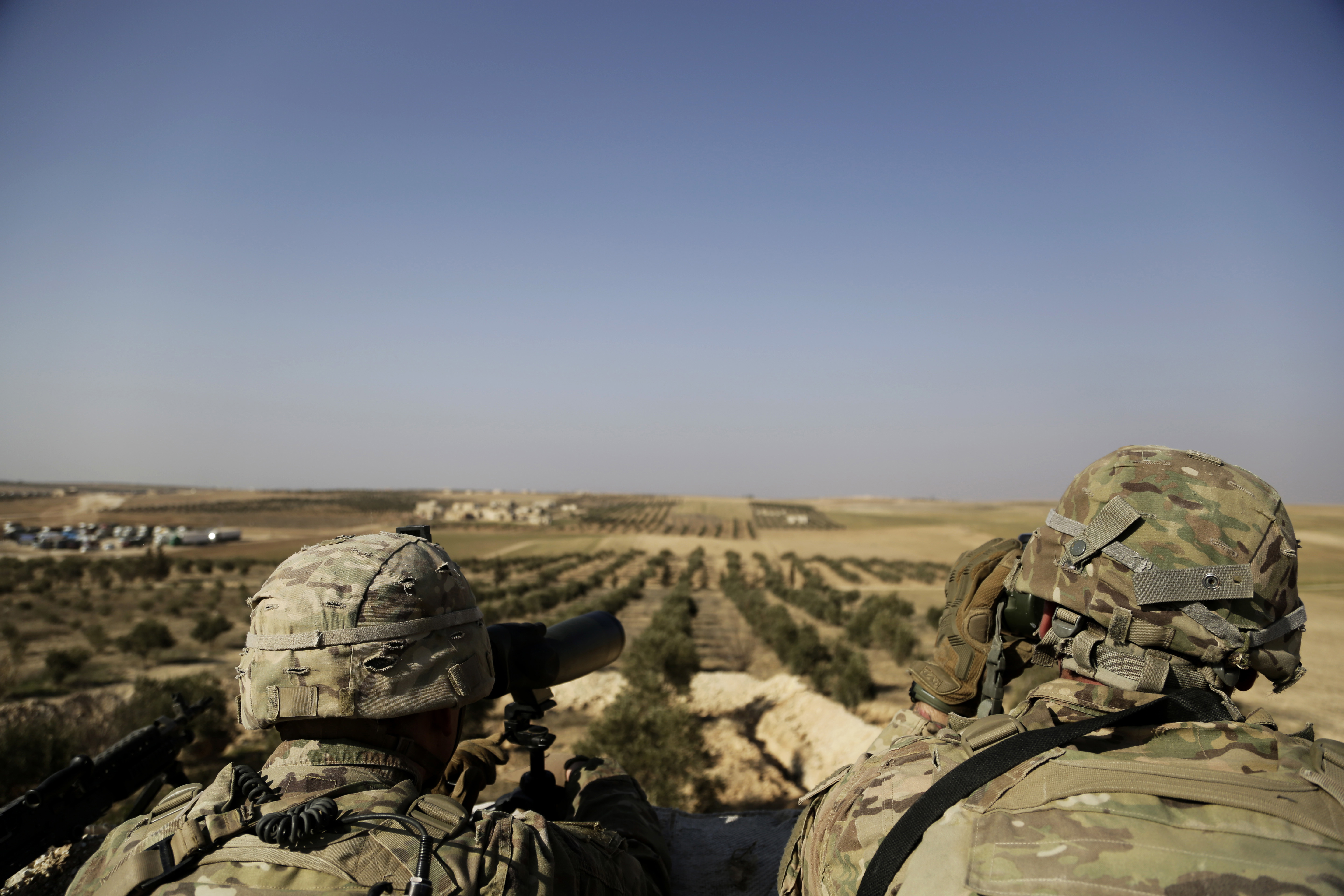 American troops look toward the border with Turkey from a small outpost near the town of Manbij, northern Syria, in February.