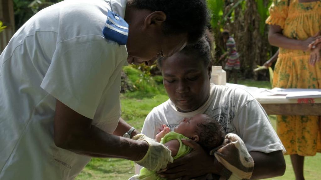 Registered Nurse Miriam Nampil vaccinates 1-month-old Joy Nowai, as she is held by her mother, Julie Nowai. The island nation of Vanuatu has launched a drone-delivered vaccination program to reach children in remote areas. (UNICEF)