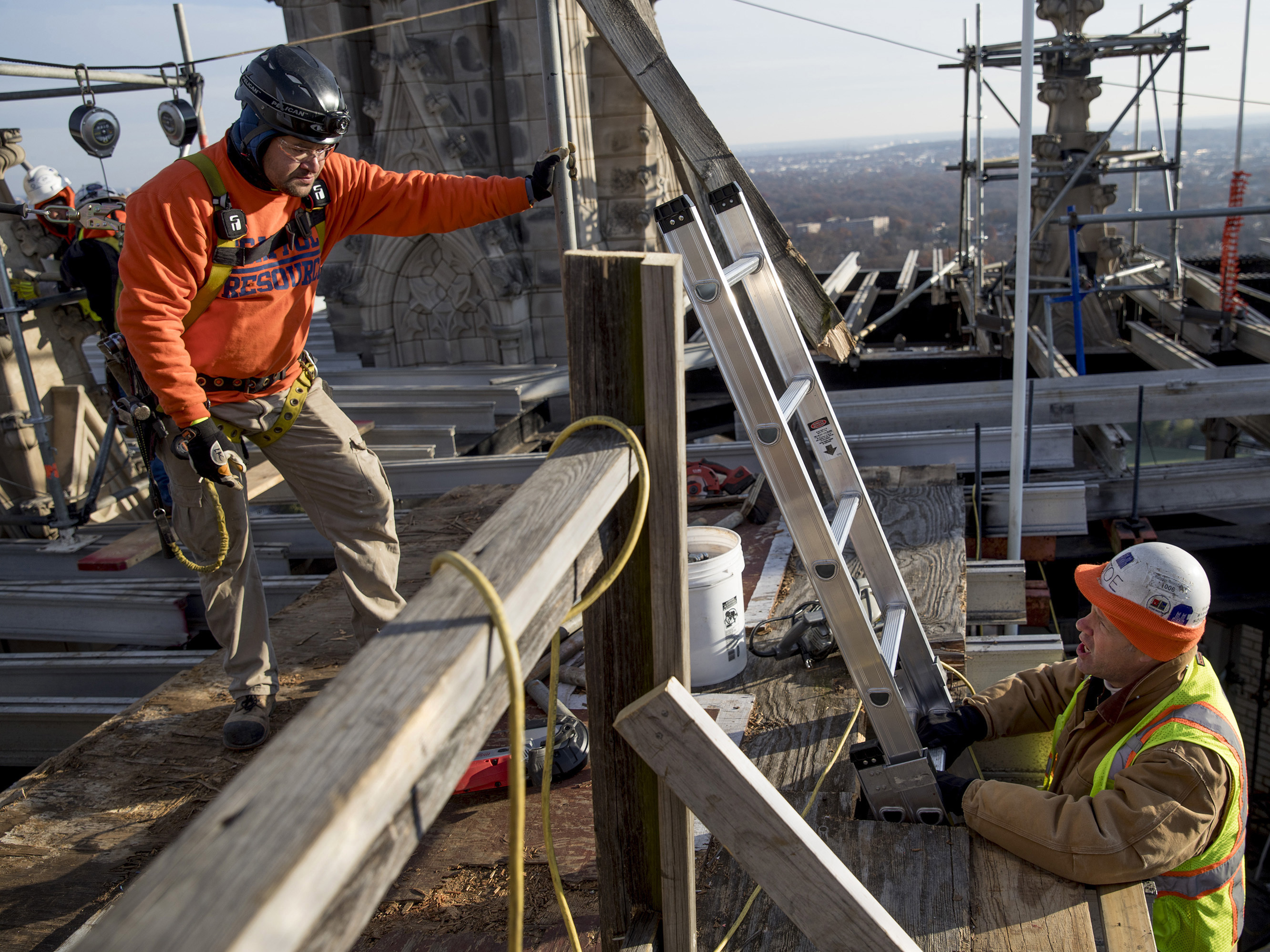 Chip By Chip, Restoring The Damaged Washington National Cathedral 1 Joe Alonso, head stonemason (right), talks with one of his construction crew members as they work on the scaffolding on top of one of the towers.