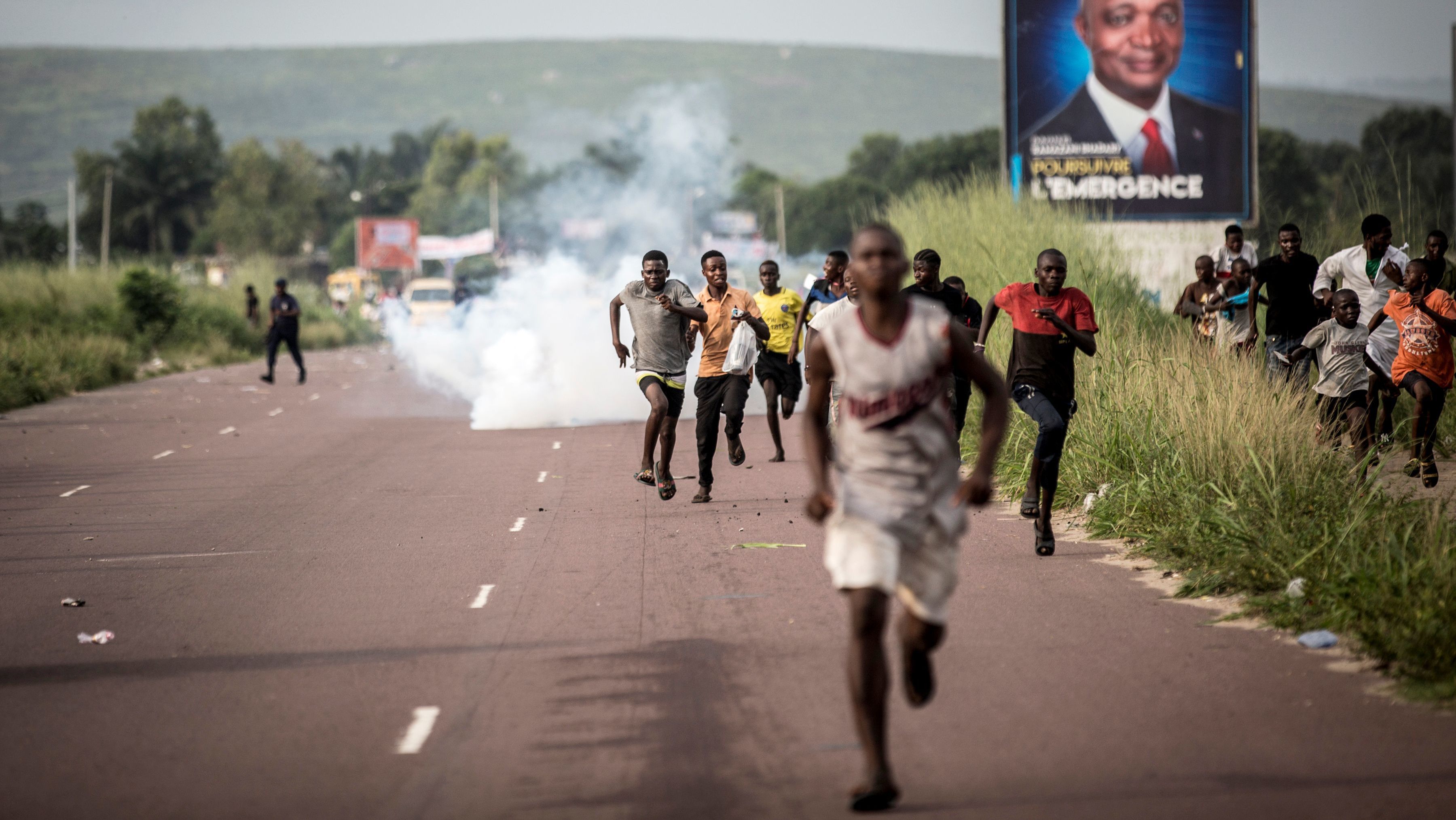 Supporters of opposition leader Martin Fayulu flee a plume of teargas fired by police Wednesday in the capital, Kinshasa.