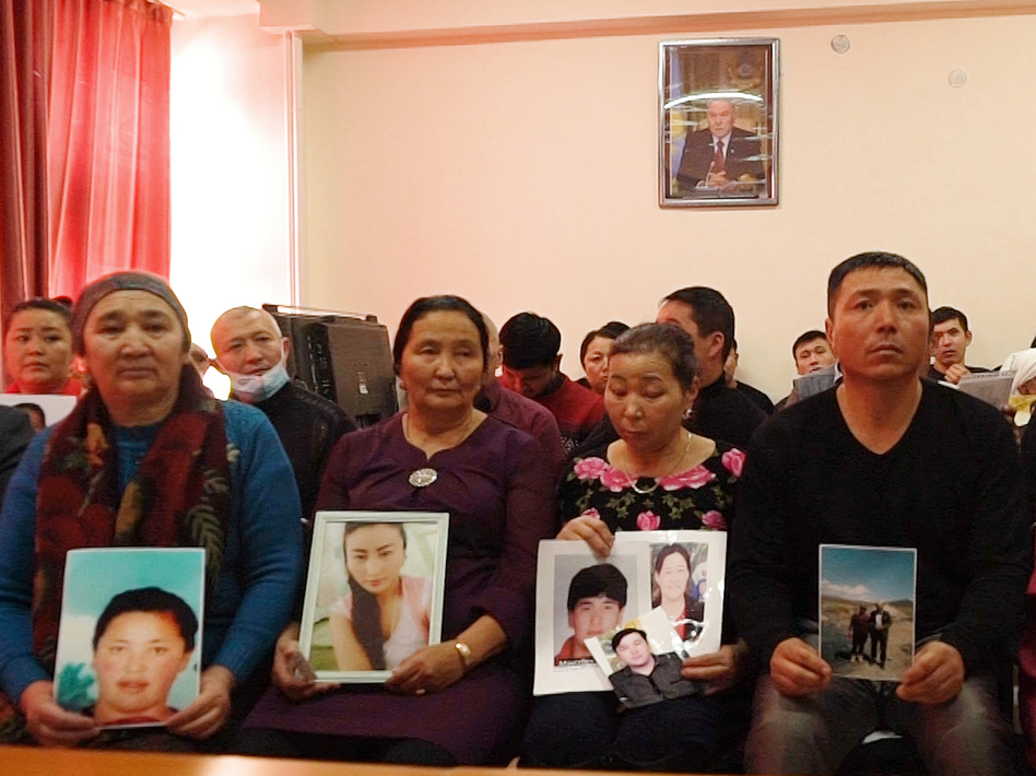In this Dec. 7, 2018, relatives of people missing in China's far western region of Xinjiang hold up photos at an office of a Chinese Kazakh advocacy organization in Almaty, Kazakhstan. (Dake Kang/AP)
