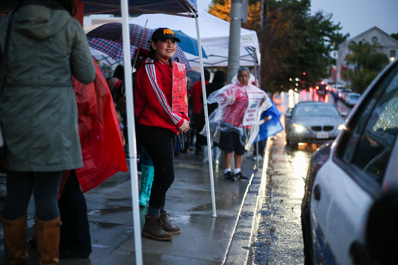 A demonstrator outside Hollenbeck Middle School in Boyle Heights, Los Angeles, flashes a friendly smile to passersby. (Roxanne Turpen for NPR)