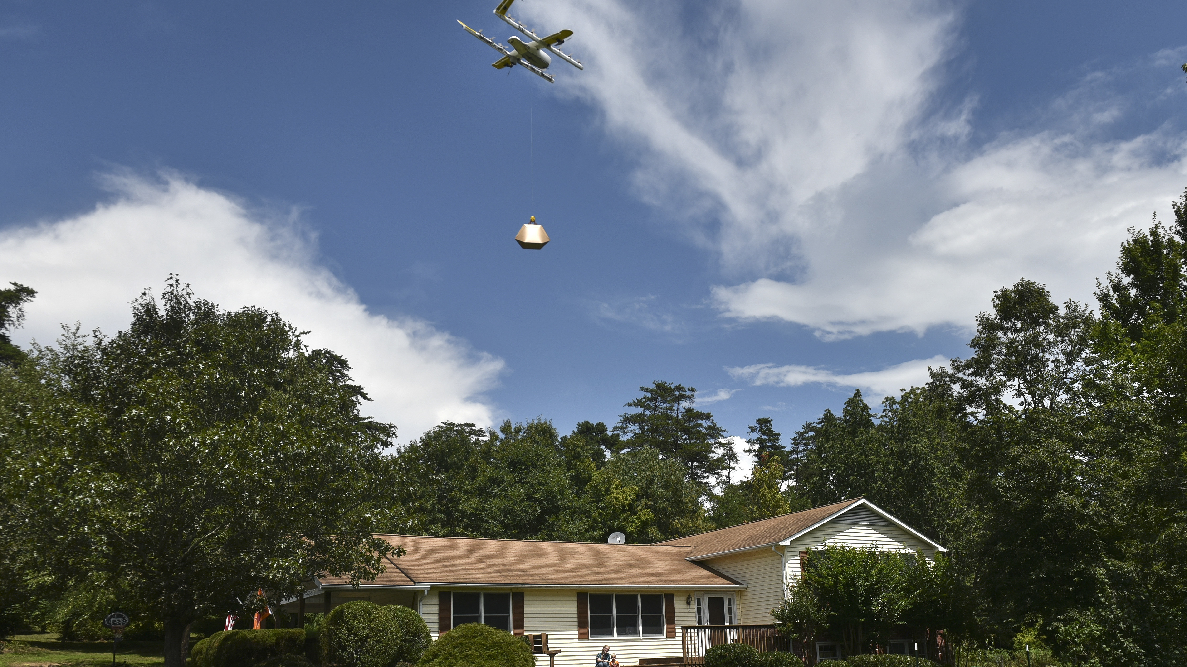 Federal regulators have announced plans to allow drone operators to fly their unmanned aerial vehicles over populated areas and at night. A Wing Hummingbird drone from Project Wing arrives and sets down its package at a delivery location in Blacksburg, Va., last year.