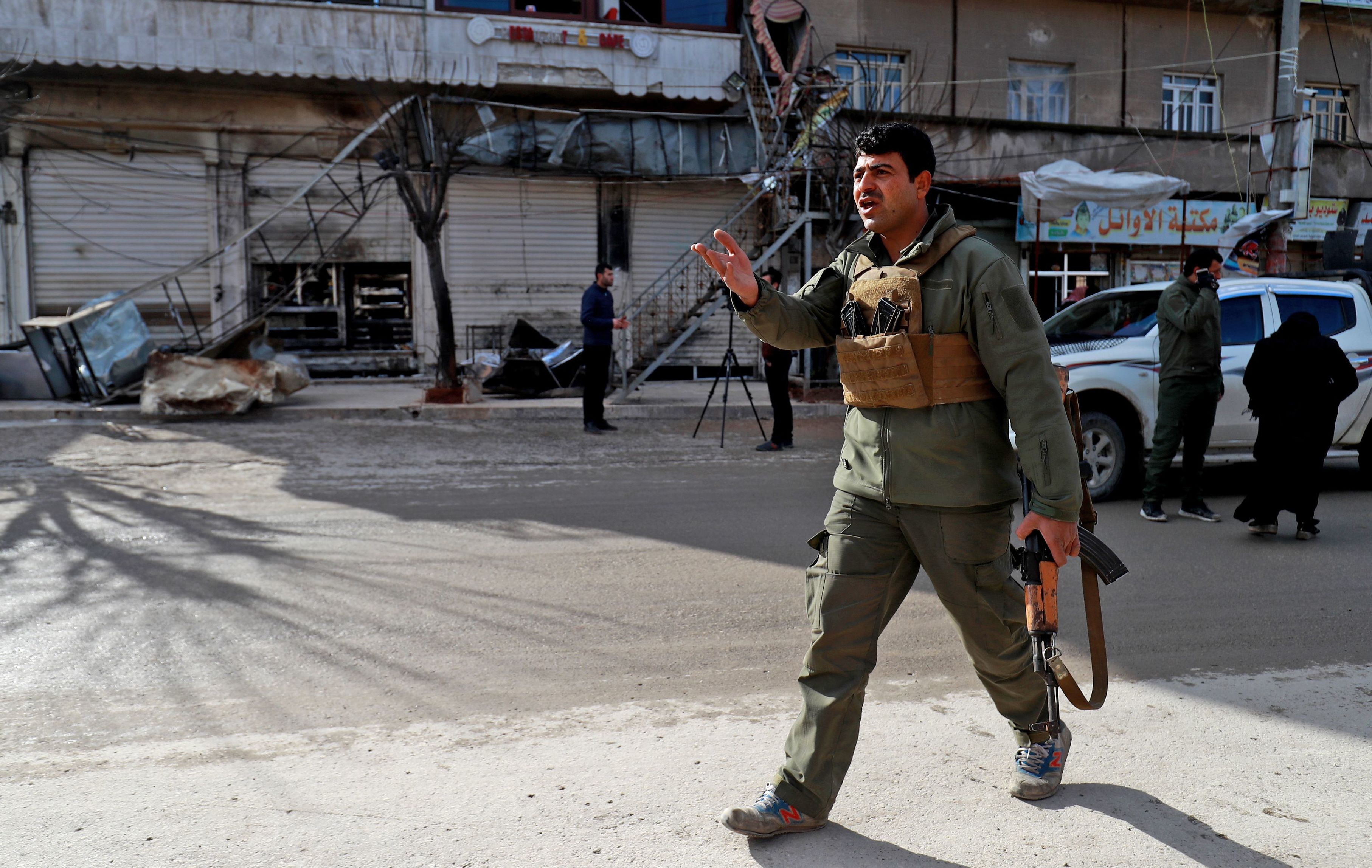 A security force member walks outside a shuttered restaurant Thursday in Manbij, Syria, the site of a suicide attack that killed more than a dozen people, including four Americans, a day earlier. The Islamic State claimed responsibility for the attack. (AFP/Getty Images)