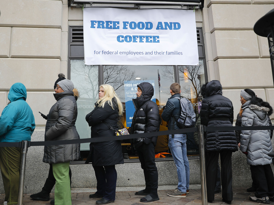 People wait in line at Chef Jose Andres' World Central Kitchen for free meals to workers affected by the government shutdown in Washington, DC.