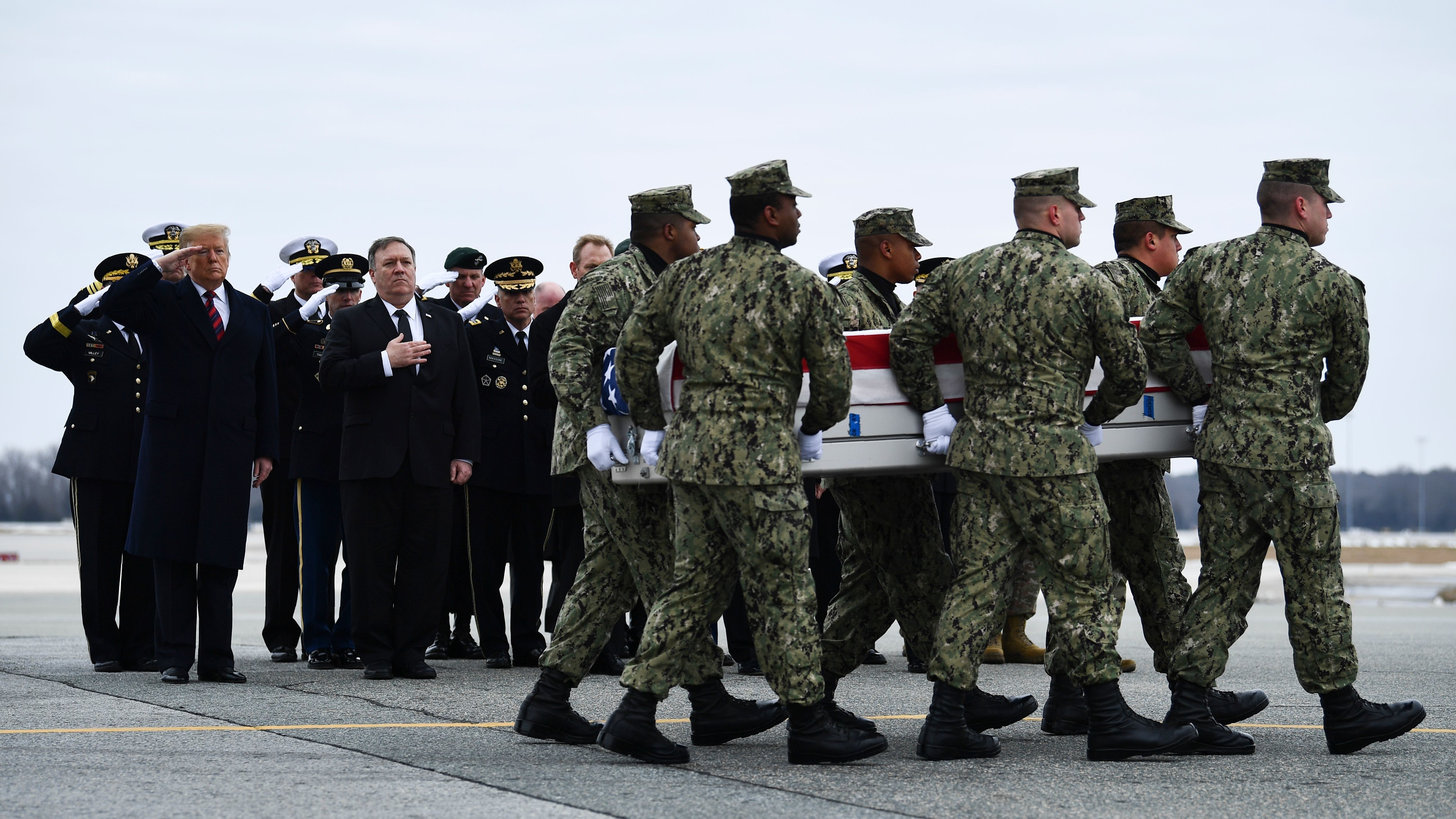 As President Donald Trump and Secretary of State Mike Pompeo watch, a U.S. Navy team moves a transfer case containing the remains of Scott A. Wirtz, Saturday at Dover Air Force Base. (AFP/Getty Images)