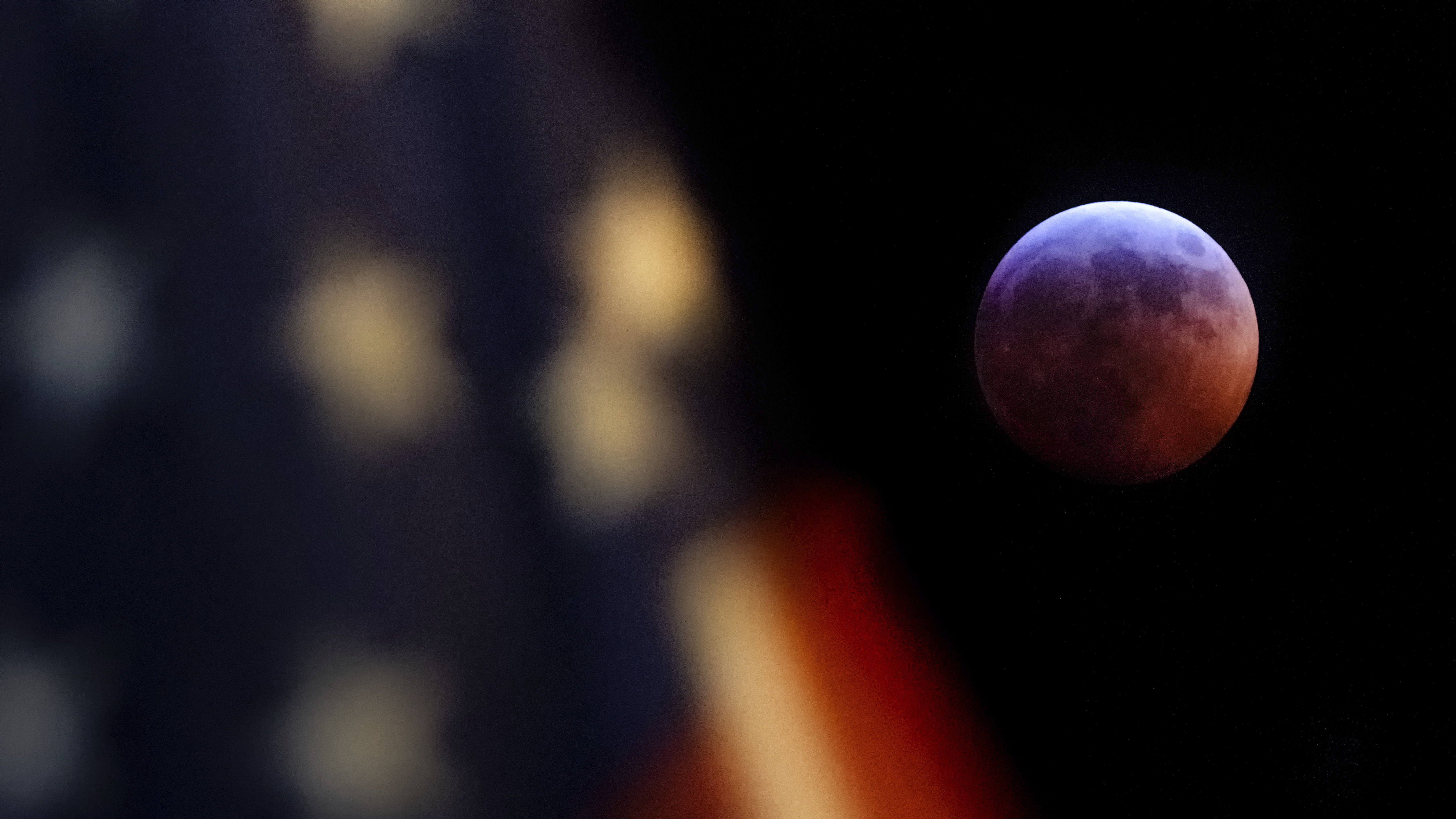 A U.S. flag flies in the foreground of this image of the moon during the lunar eclipse as seen from Washington, D.C., on Sunday night.