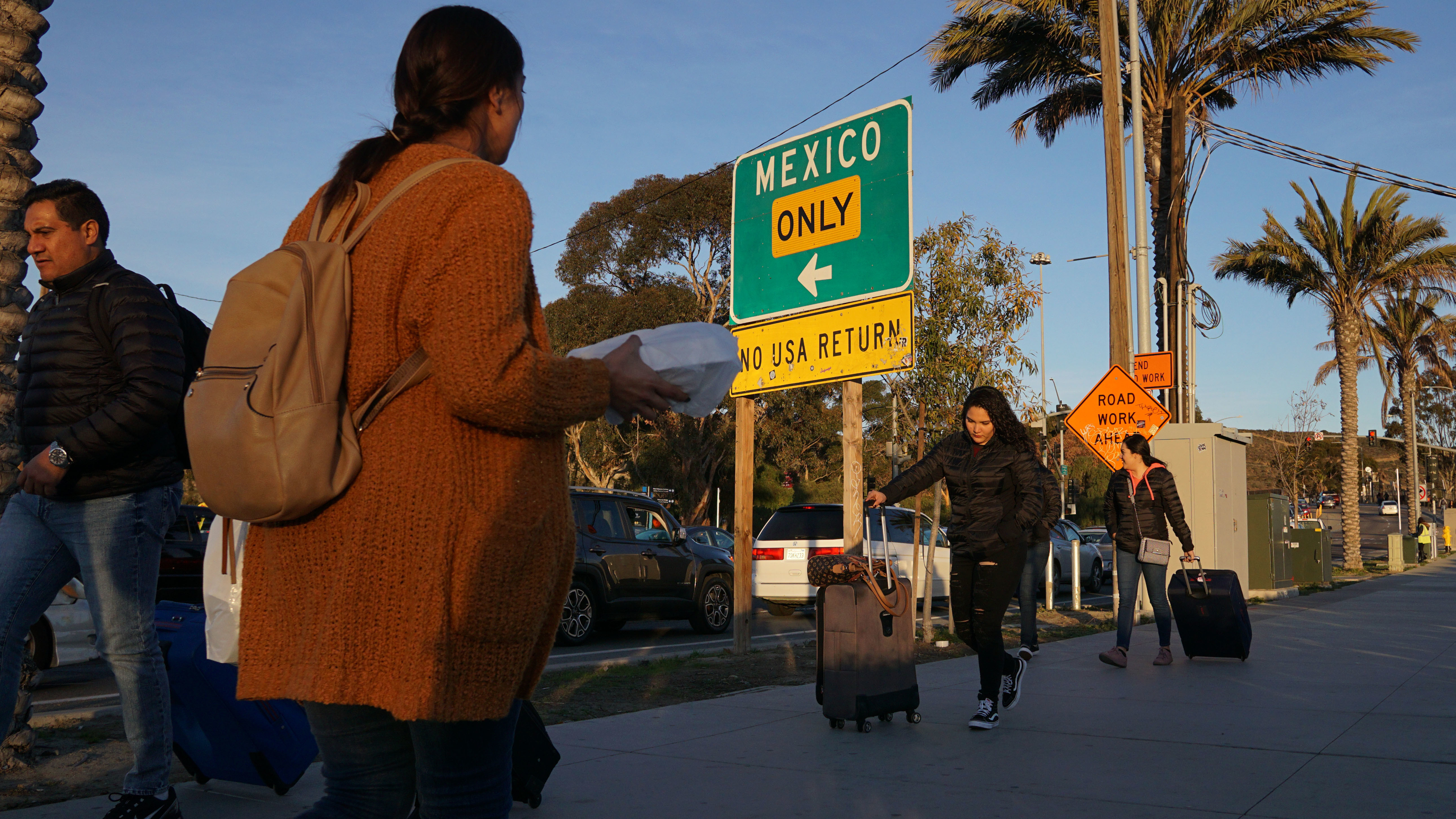 Shoppers walk toward the San Ysidro, Calif., Port of Entry after making purchases at outlet malls along the US-Mexico border on Dec. 29.