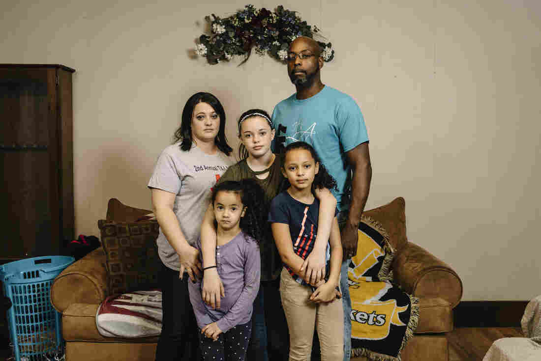 Tiffany Kirklin stands with her husband, James, and their daughters (from left) Abbie, 7, Mandi, 12, and Natalee, 9, in the living room of their home in Kinder, La. Tiffany and James are among the workers at a local federal prison who are affected by the government shutdown.