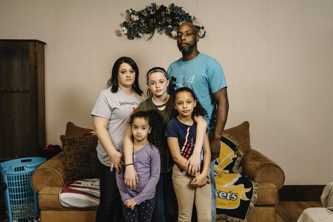 Tiffany Kirklin stands with her husband, James, and their daughters (from left) Abbie, 7, Mandi, 12, and Natalee, 9, in the living room of their home in Kinder, La. Tiffany and James are among the workers at a local federal prison who are affected by the government shutdown.