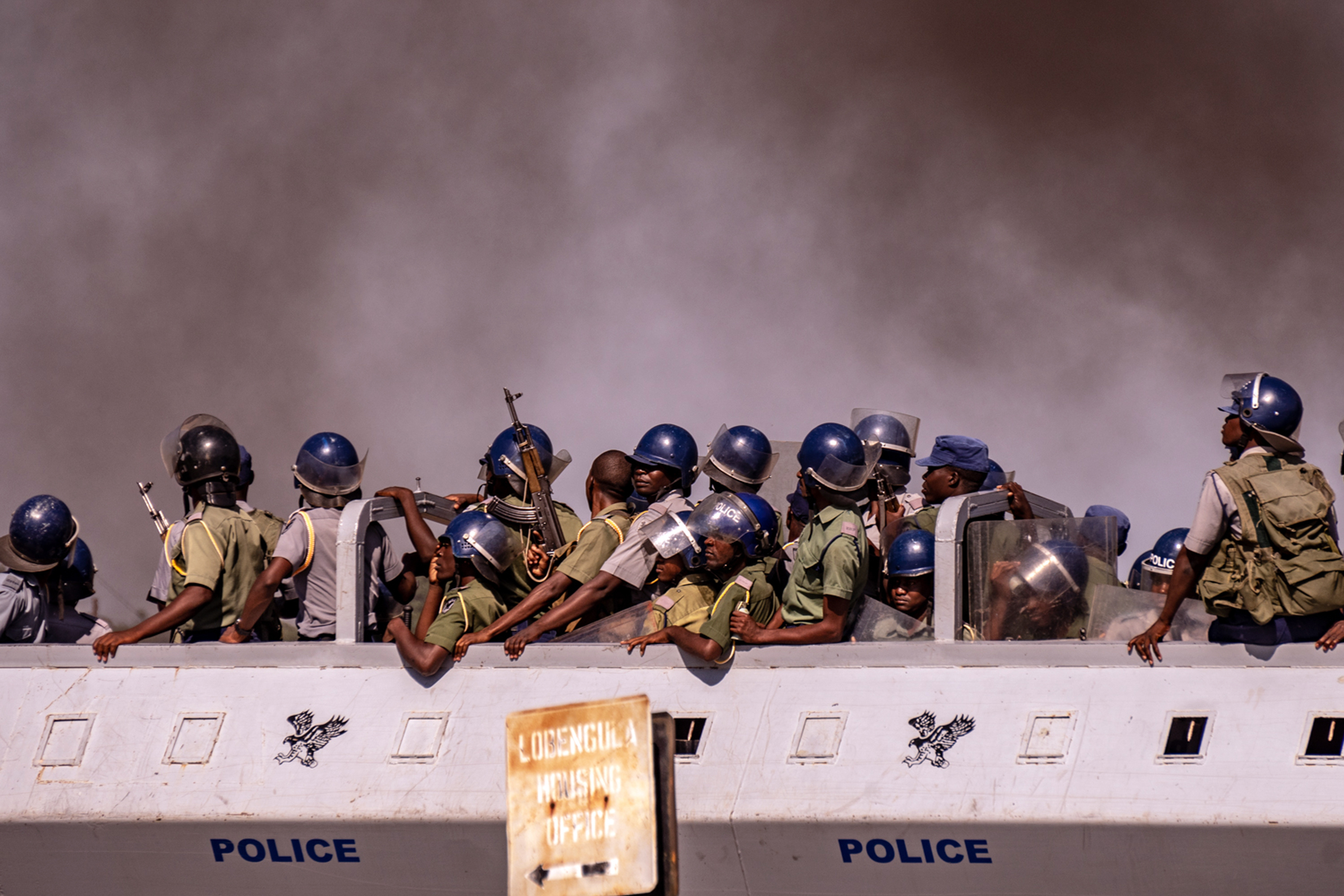 A police truck drives past a thick cloud of smoke as protesters burn tires in Bulawayo, Zimbabwe, during a tense, three-day nationwide protest against a fuel price hike in January. (Tendai Marima)