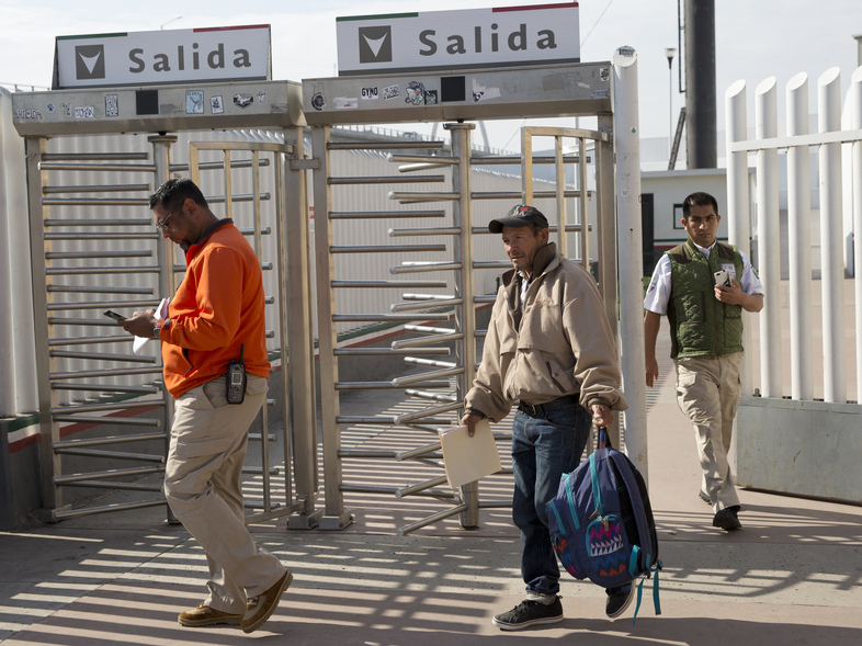 Carlos Catarldo Gomez, of Honduras, center, is escorted by Mexican officials after leaving the United States, the first person returned to Mexico to wait for his asylum trial date, in Tijuana, Mexico (Gregory Bull/AP)