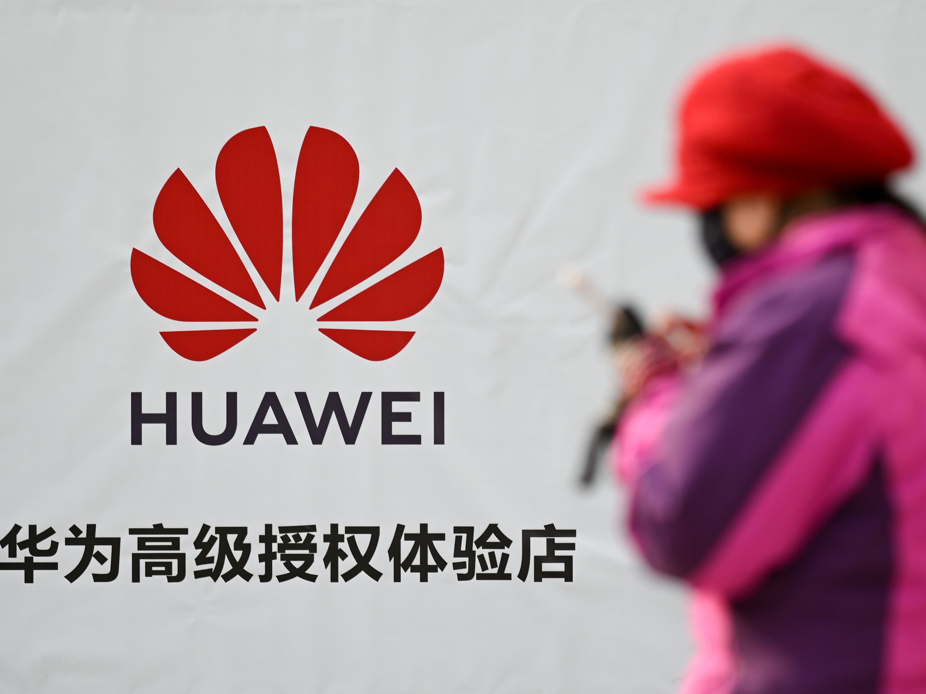 A Justice Department indictment unsealed on Monday details an alleged conspiracy by the Chinese device maker Huawei to steal the details of a T-Mobile robot. Here, a woman uses her smartphone outside a Huawei store in Beijing on Tuesday. (AFP/Getty Images)