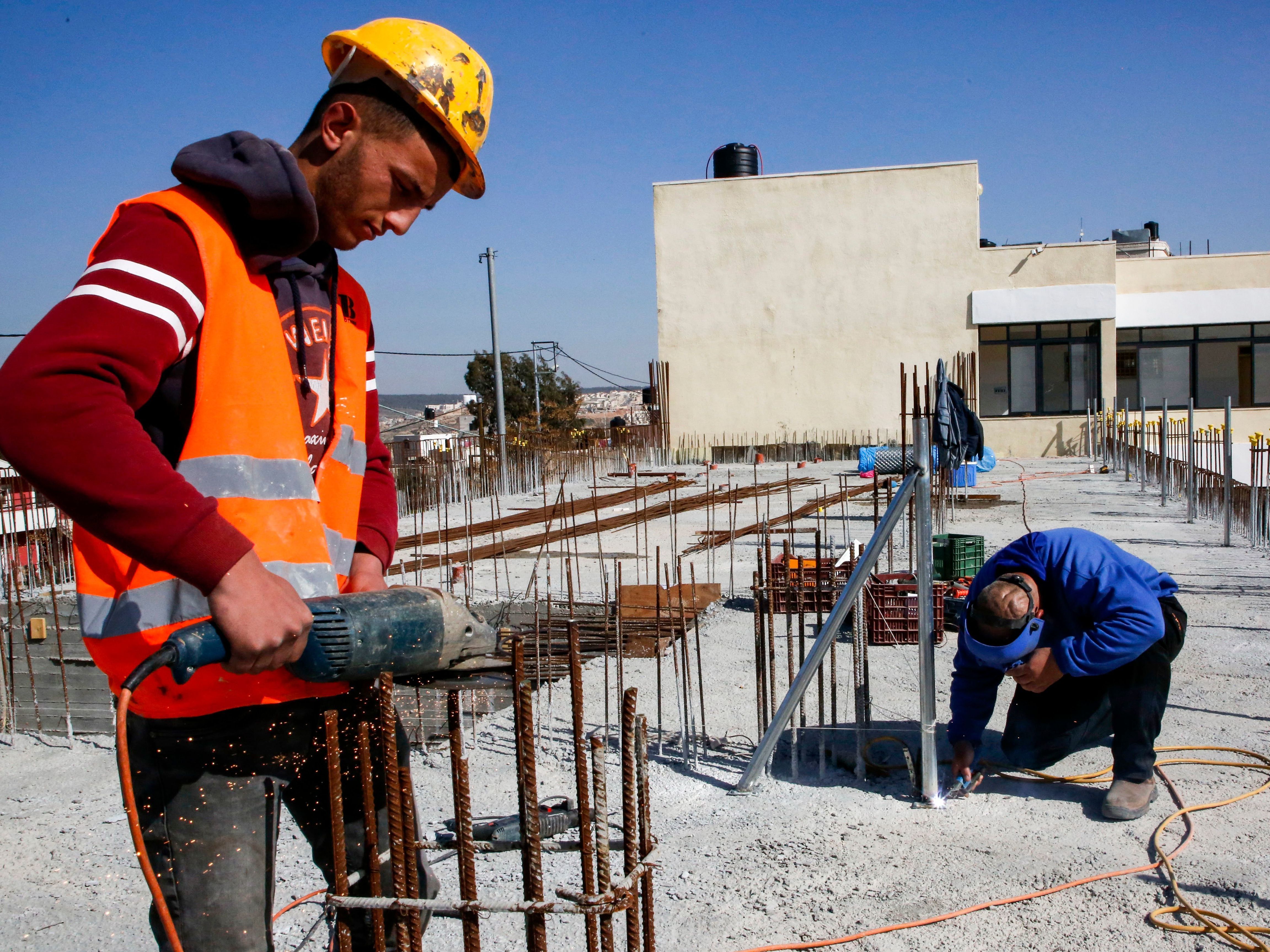 A construction worker saws steel rods at the site of a school that was funded by the United States Agency for International Development in the Palestinian village of al-Jabaa, in the West Bank, on Jan. 22. (AFP/Getty Images)