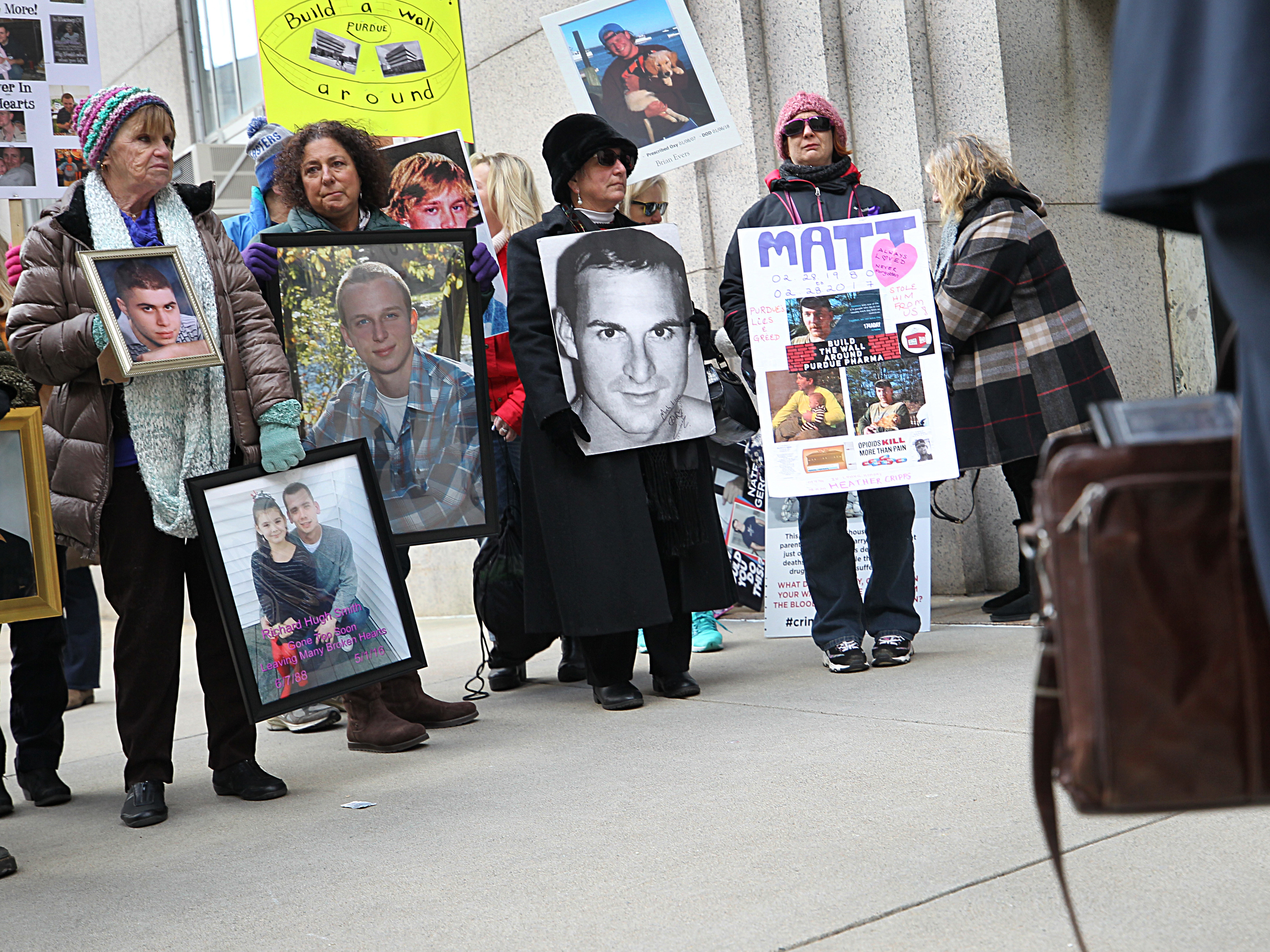 Families that lost loved ones to the opioid crisis protested outside Suffolk Superior Court in Boston as lawyers for Purdue Pharma entered the courthouse for a status update in the Massachusetts attorney general's suit against the company on Jan. 25. (Boston Globe via Getty Images)