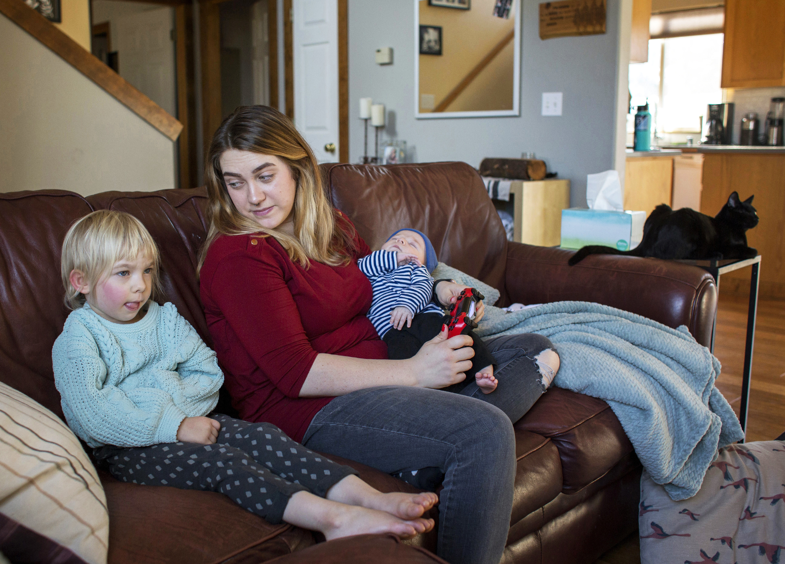 Amber Gorrow and her daughter, Eleanor, 3, pick out a show to watch after Eleanor's nap at their home in Vancouver, Wash., on Wednesday. Eleanor has gotten her first measles vaccine, but Gorrow's son, Leon, 8 weeks, is still too young to be immunized. (Getty Images)