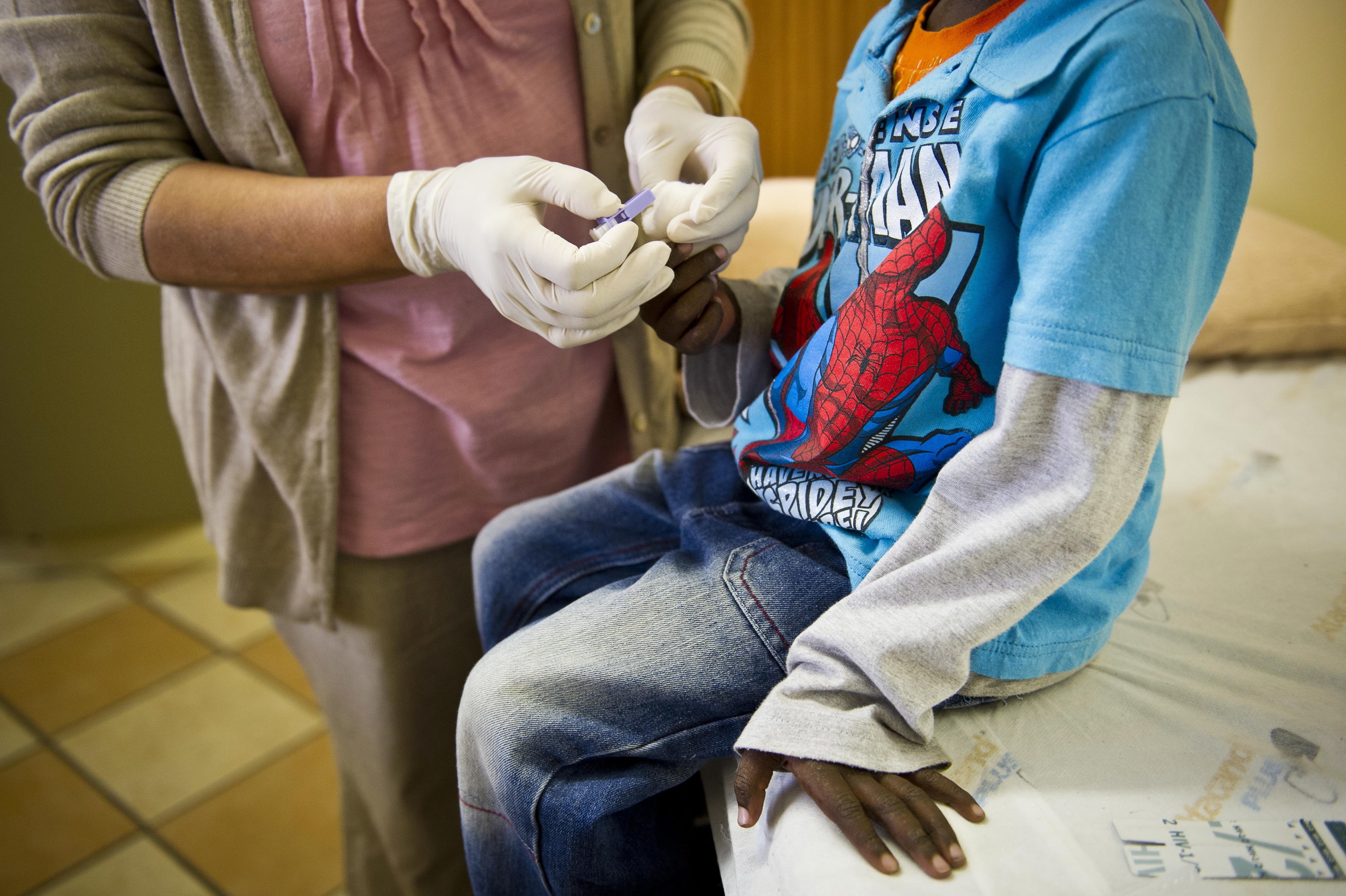 A staffer at the Right to Care AIDS clinic in Johannesburg administers an HIV test on a young boy. South Africa is one of the countries that receives funds from the U.S. President's Emergency Plan for AIDS Relief (PEPFAR).