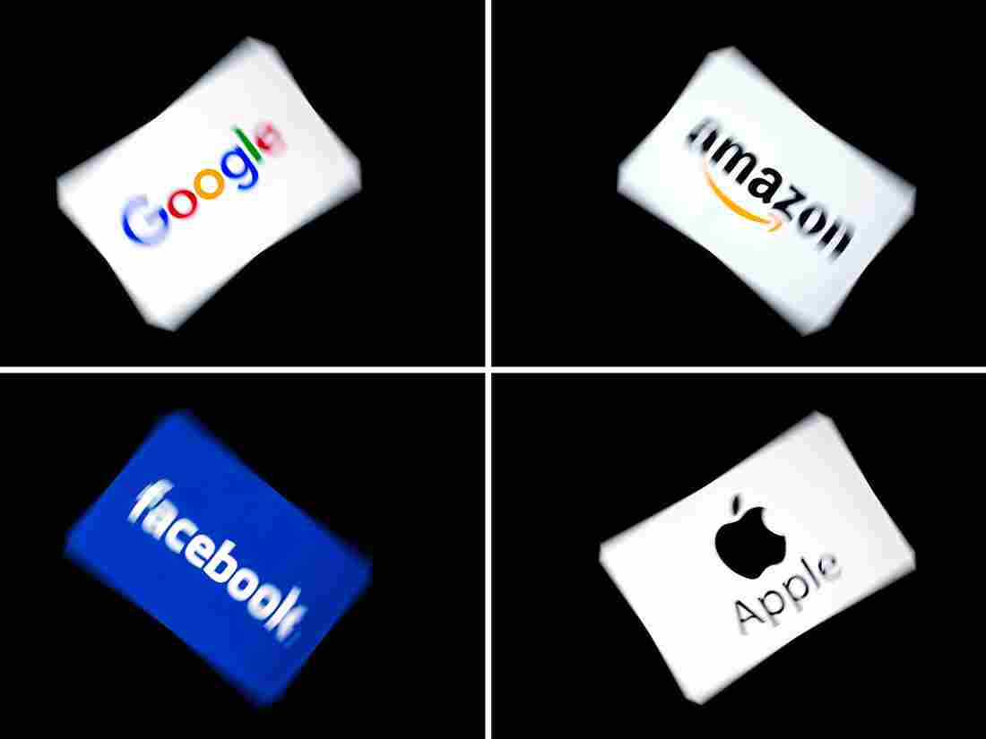 This combination of pictures shows the logos of Google, Amazon, Facebook, and Apple, displayed on a tablet in Paris, on February 18, 2019.