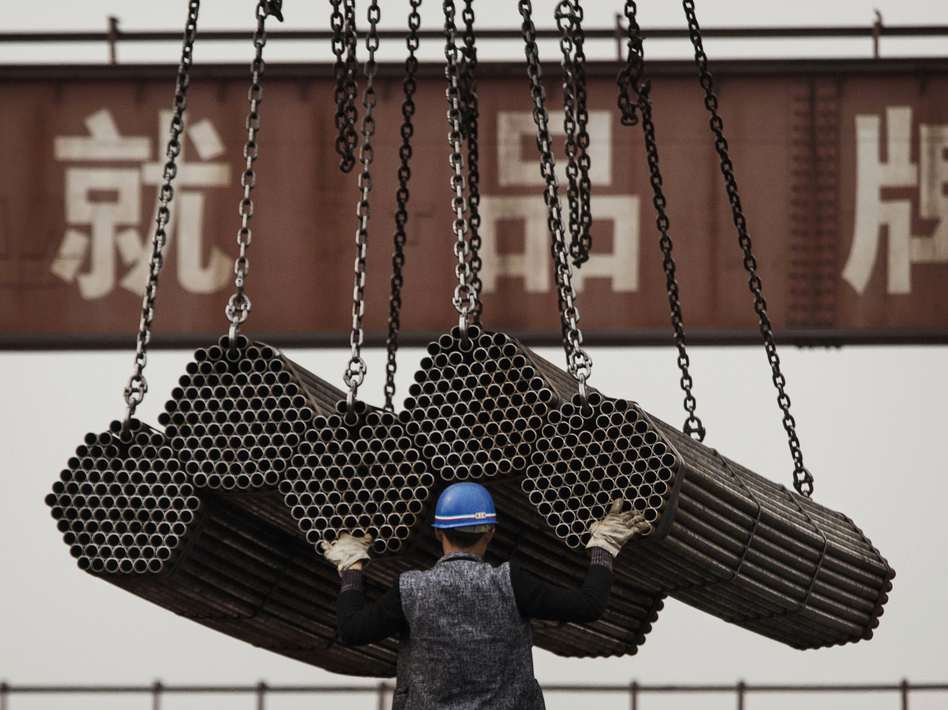 A worker helps load steel rods April 6, 2016, at a plant in Tangshan, in China's Hebei province. China's government plays a powerful role in how its businesses operate — giving them preferential treatment over their rivals. (Kevin Frayer/Getty Images)