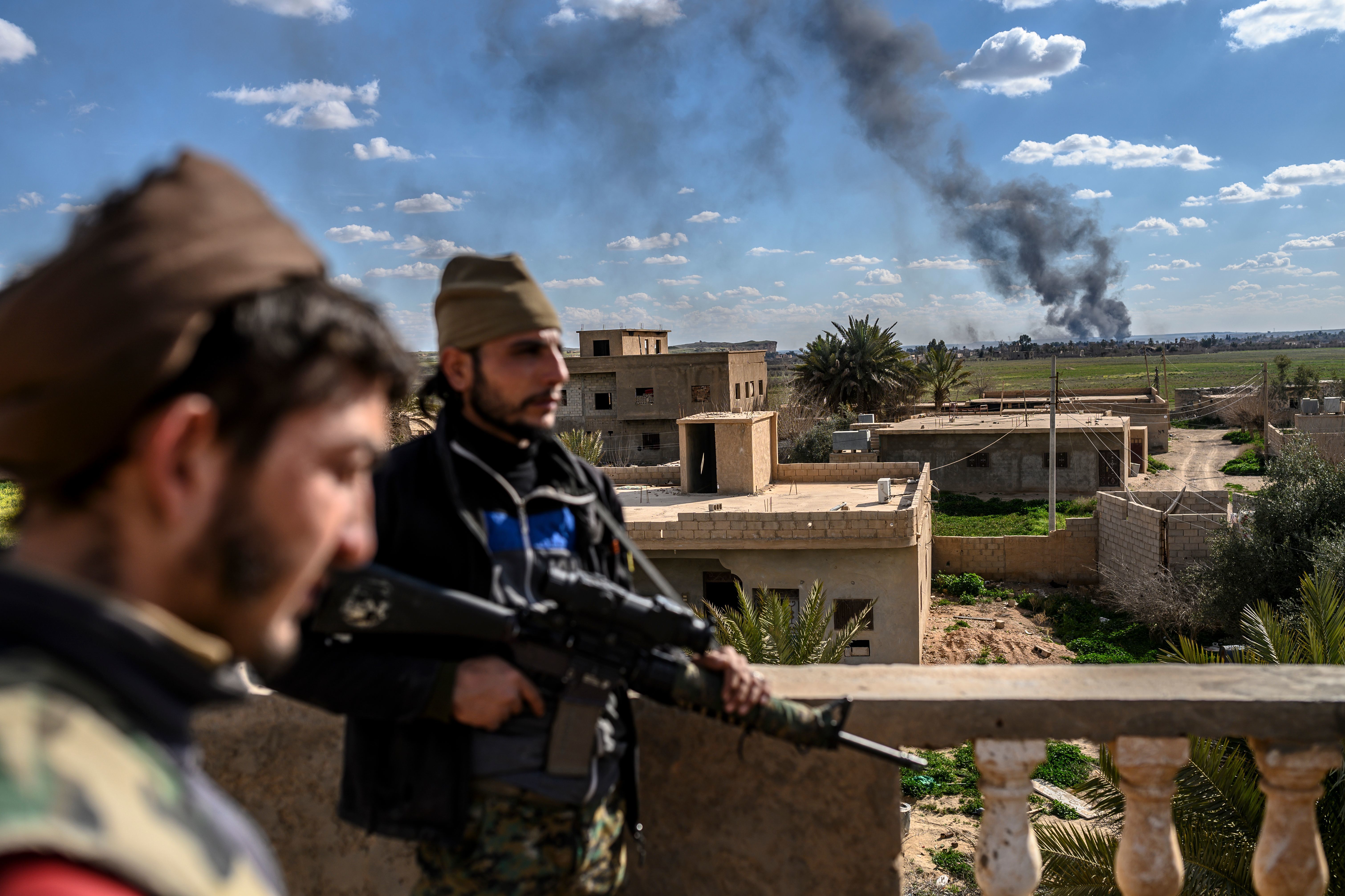 U.S.-backed fighters stand guard on a building during shelling of the Islamic State's last holdout in the town of Baghouz, Syria, on March 3. (AFP/Getty Images)