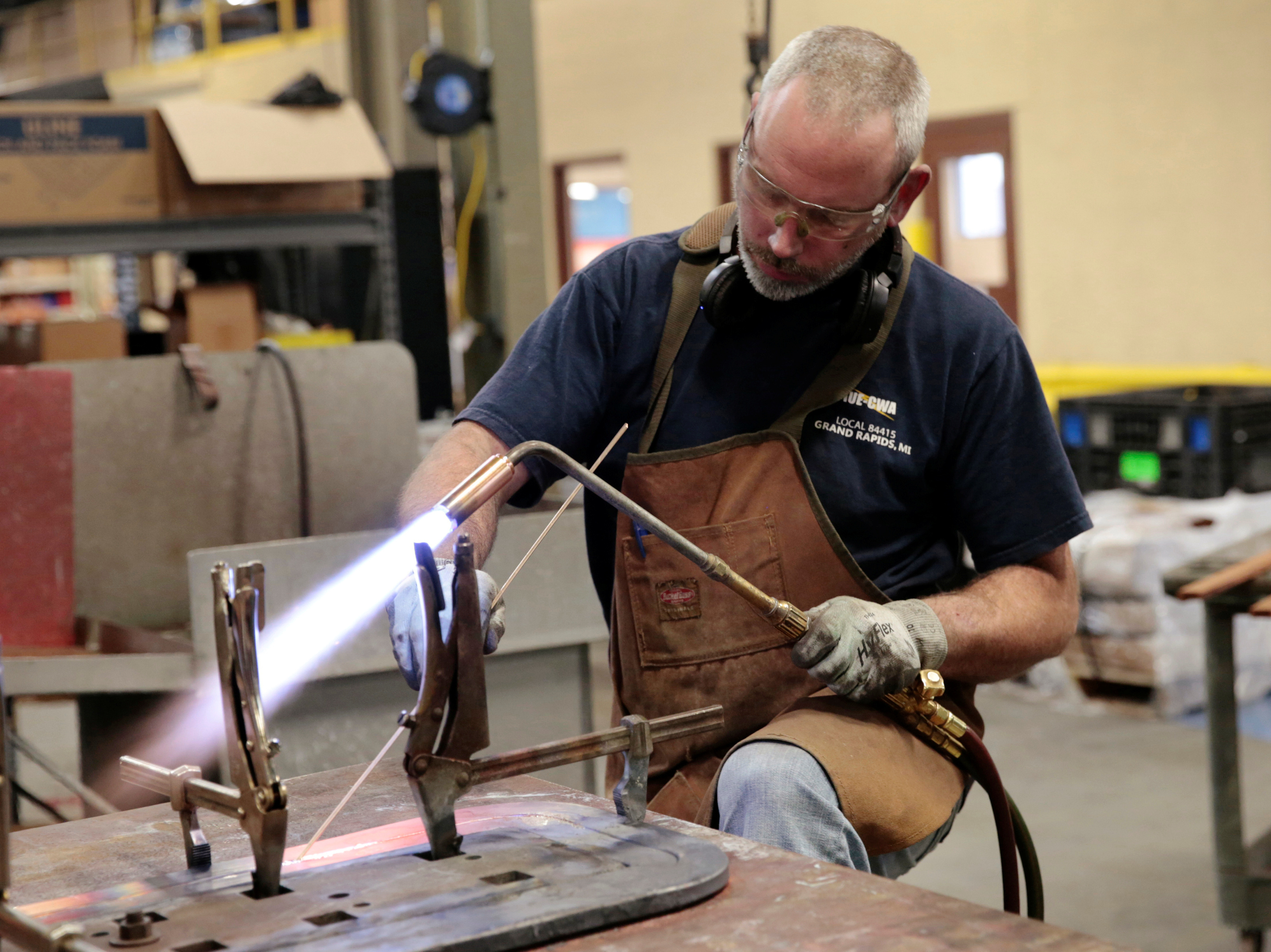 Nate Poort works on braizing loops together for transformers at RoMan Manufacturing in Grand Rapids, Mich., on Dec. 12, 2018. (Reuters)
