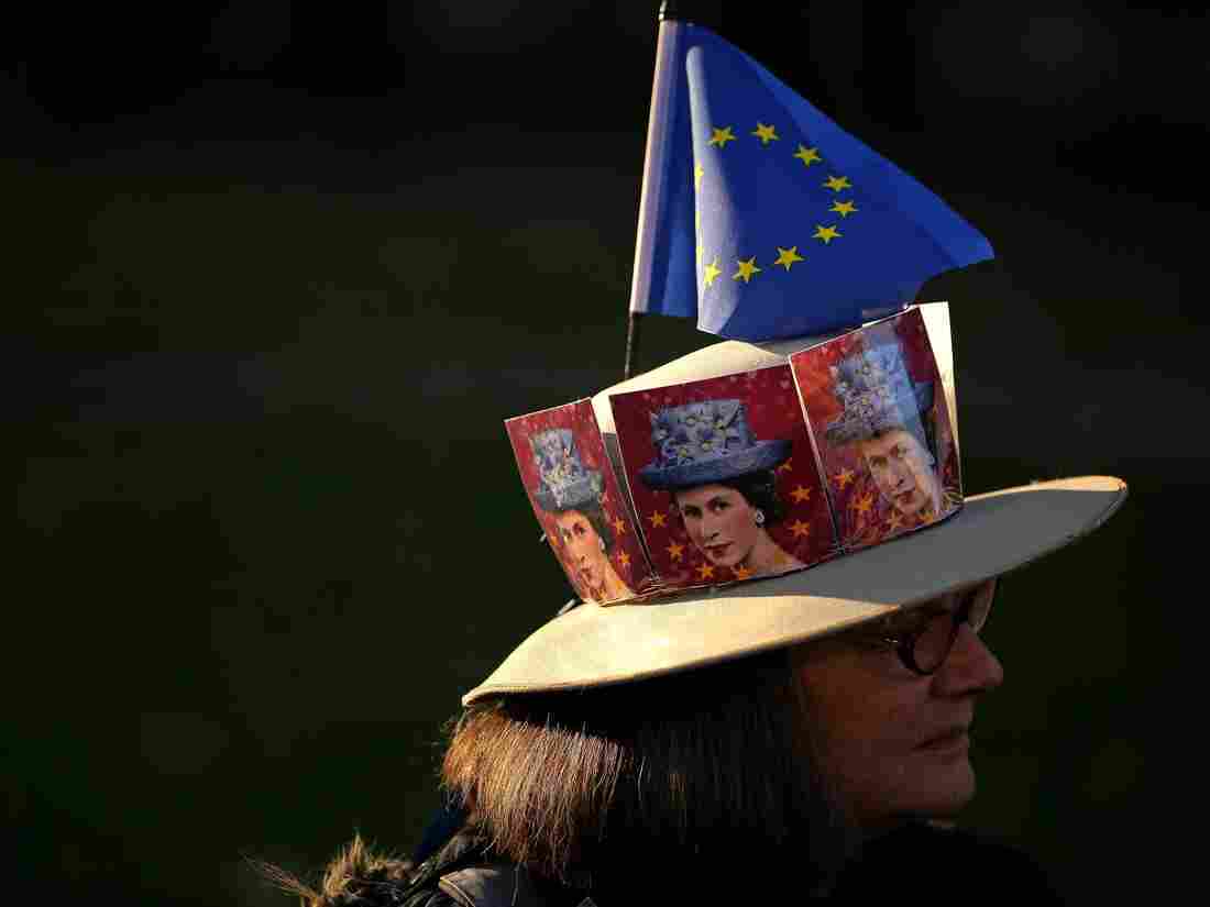 A pro-Brexit activist wears a hat decorated with pictures of Britain's Queen Elizabeth II and an EU flag as they demonstrate outside the Houses of Parliament in central London on February 27, 2019. (Photo by Daniel LEAL-OLIVAS / AFP) (Photo credit should read DANIEL LEAL-OLIVAS/AFP/Getty Images)
