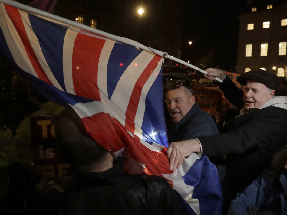 Brexit supporters and opponents shout at each other outside Parliament in London on Thursday, the day that British lawmakers voted to delay Brexit.
