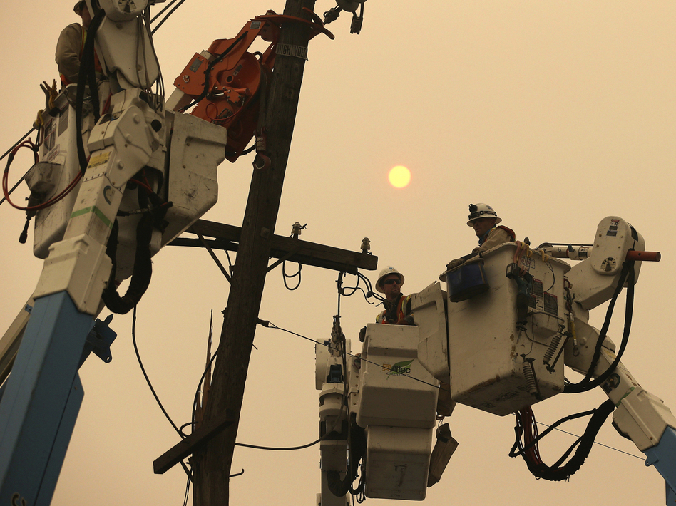 PG&E crews work to restore power lines in Paradise, Calif., after the Camp Fire destroyed much of the Northern California town.