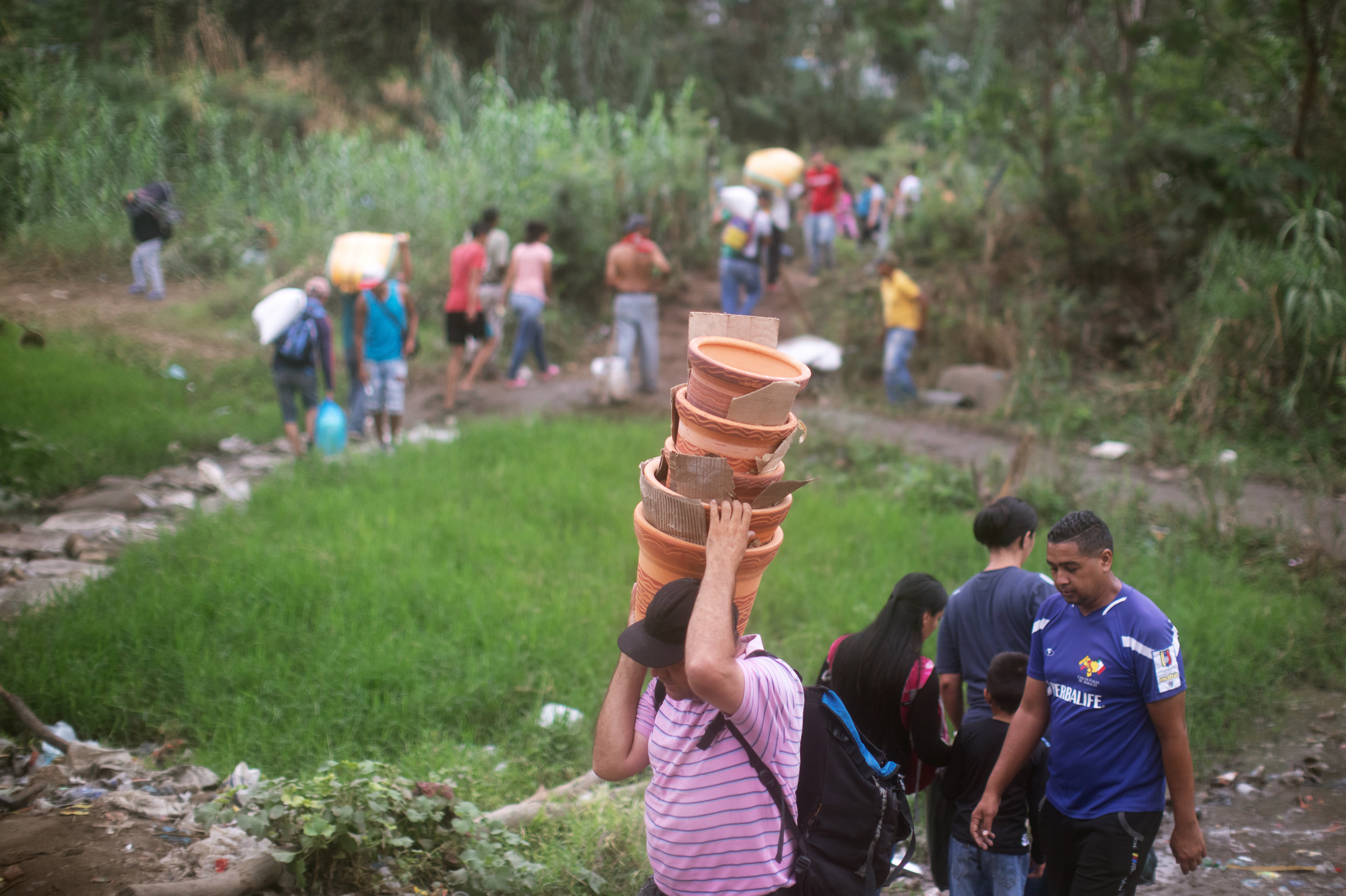 People walk from Venezuela to Colombia through an unauthorized border crossing in Villa del Rosario, Colombia. Some 3.4 million Venezuelans are seeking refuge abroad, with more than 1 million of them in neighboring Colombia, according to the United Nations refugee agency, UNHCR. Many people are leaving Venezuela by foot. (NPR)