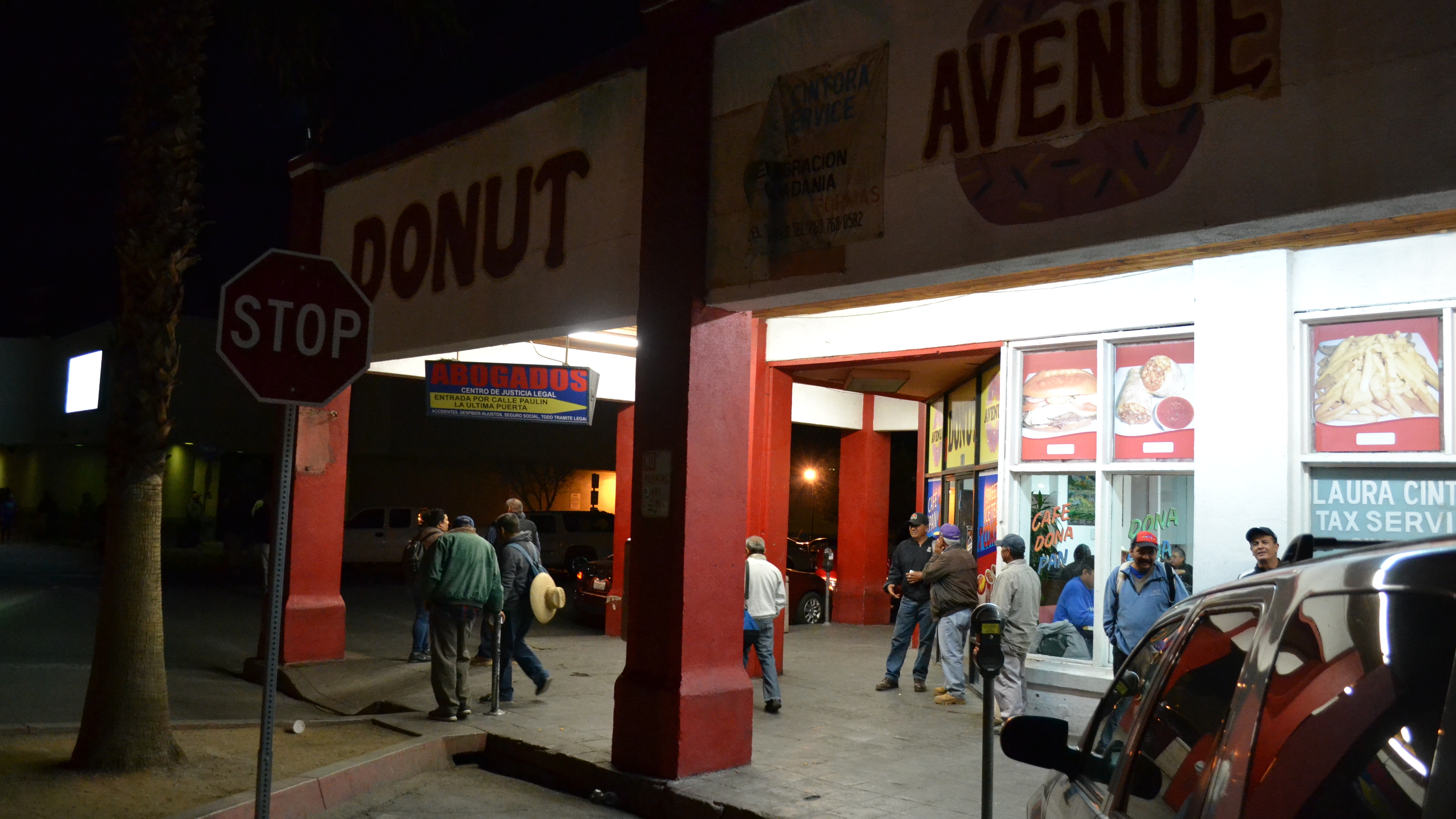 Mexican agricultural workers wait at a Calexico doughnut shop before dawn to be driven to farms in the Imperial Valley after crossing the border. President Trump is scheduled to visit Calexico, Calif., on Friday. (Max Rivlin-Nadler for NPR)
