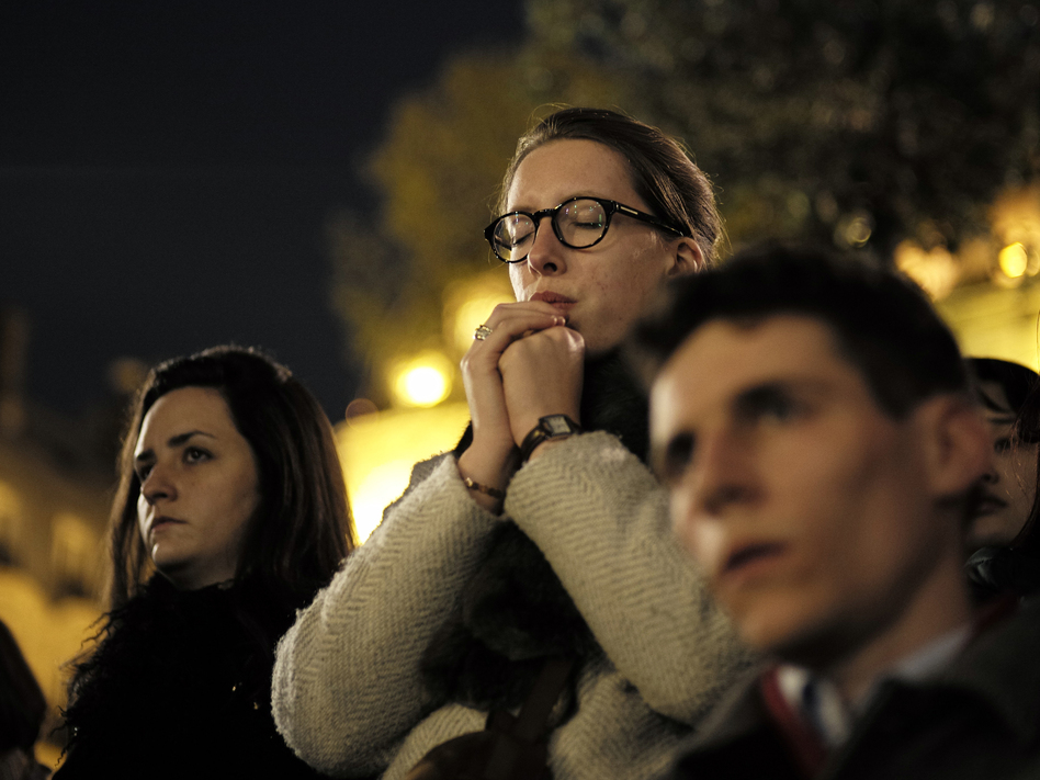 People attend a vigil in Paris on Tuesday following the devastating fire that destroyed much of the beloved Notre Dame Cathedral. (Kamil Zihnioglu/AP)