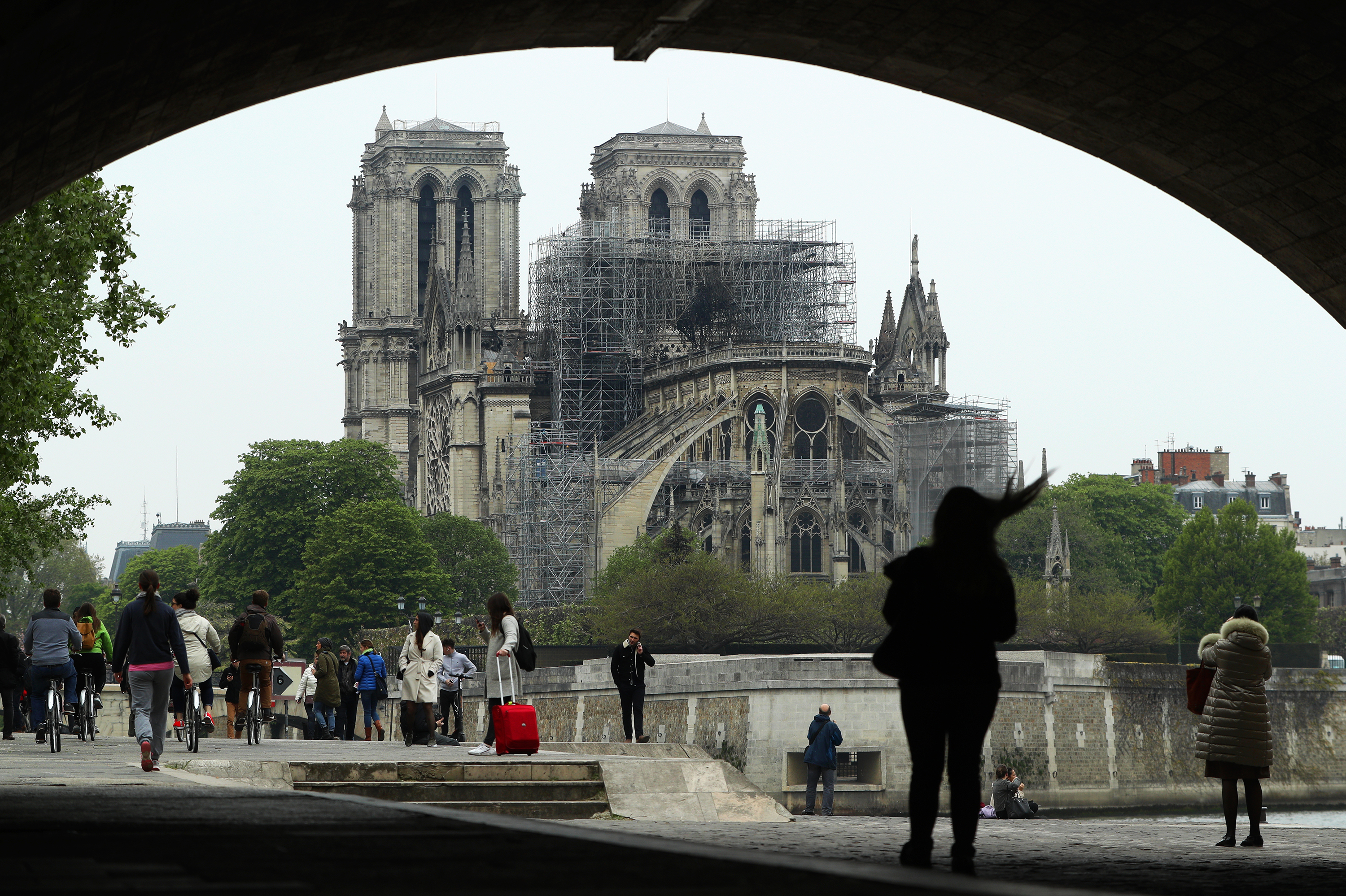 People look up at the damage caused to Notre Dame Cathedral on Tuesday in Paris. A fire broke out on Monday afternoon and quickly spread across the building, causing the famous spire to collapse. (Getty Images)