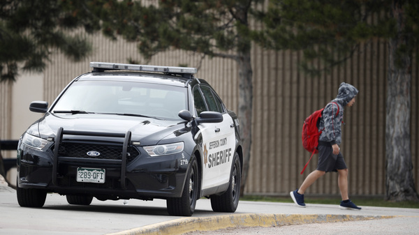 A student leaves Columbine High School late Tuesday in Littleton, Colo. Authorities say they are looking for a woman they say presented a credible threat ahead of the 20th anniversary of the mass shooting there.