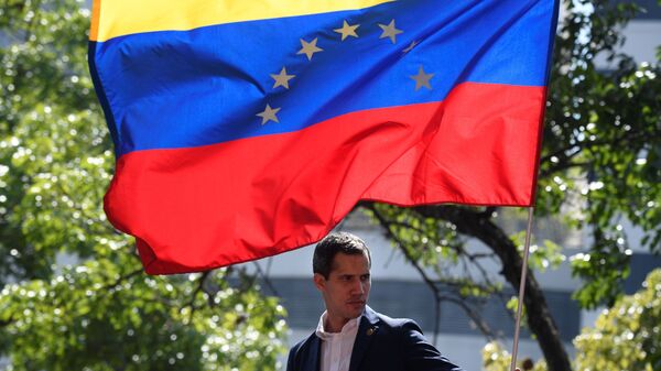 Venezuelan opposition leader and self-proclaimed acting president Juan Guaido stands under the national flag during a gathering with supporters after members of the Bolivarian National Guard joined his campaign to oust President Nicolas Maduro, in Caracas on April 30.