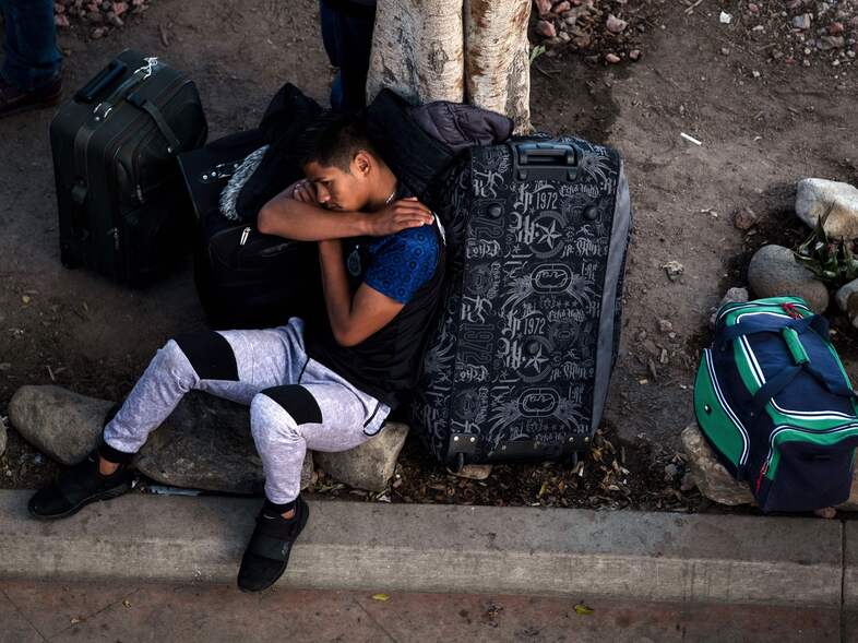 An asylum-seeker rests outside El Chaparral port of entry while he waits for his turn to present himself to U.S. border authorities to request asylum, in Tijuana, Mexico, last month. A federal appeals court has granted the Trump administration's request to temporarily allow the government to continue to return asylum-seekers to Mexico while it appeals an ruling that blocked the policy. (Guillermo Arias/AFP/Getty Images)