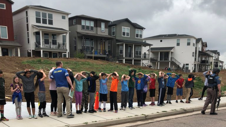 Schoolchildren stand in a line near the STEM School in Highlands Ranch during a shooting at the Colorado school, in an image obtained by Reuters via social media.