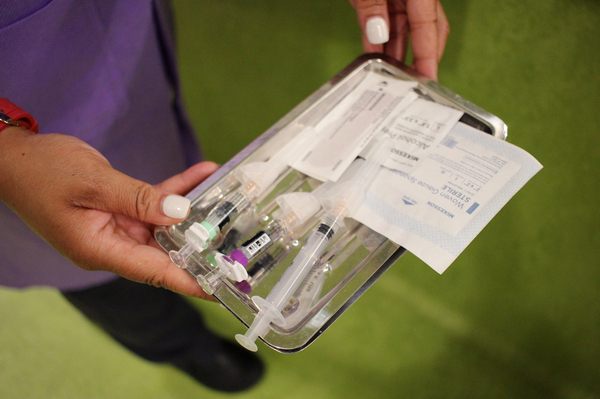 Band-aid at the ready, Sara McRae, a medical assistant at Unity Health Care, heads in to vaccinate a pediatric patient.