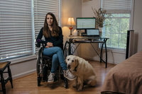 Izzie with her service dog, Zandra. Spinergy welcomed Zandra, who is able to retrieve things when Izzie drops them.