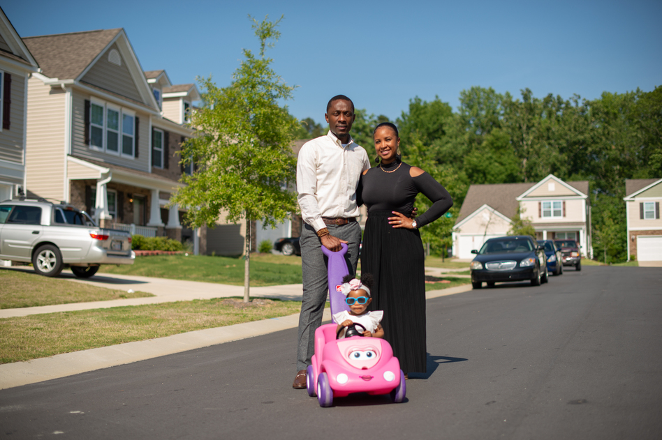 Sam Smith, Brittany Smith and their daughter Erelah outside their Charlotte home. The Smiths moved to Charlotte looking for change and opportunity. They are part of an influx of African Americans to Mecklenburg County, where the African American population has ballooned by 64% since 2000. (Swikar Patel for NPR)