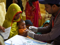 In Larkana, Pakistan, on May 9, 2019, a paramedic takes a blood sample from a baby for a HIV test. The government is offering screenings in the wake of an HIV outbreak.
