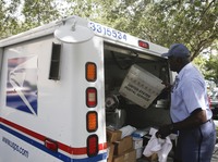 A mail carrier for the United States Postal Service makes deliveries at a Florida apartment complex in June 2018. The USPS has partnered with TuSimple to launch a multi-state driverless semi-truck test program on Tuesday. It doesn't involve home deliveries.