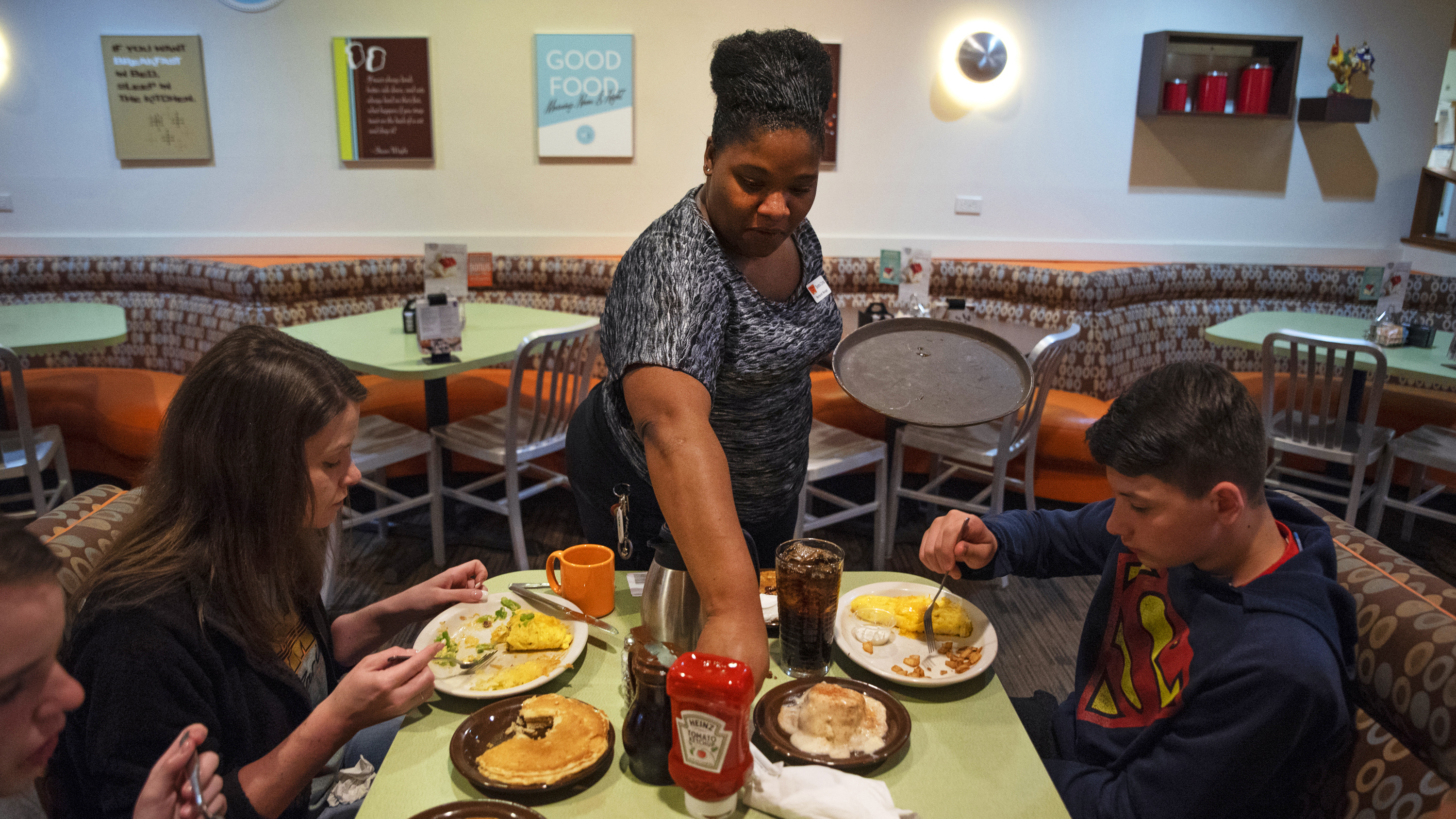 Tanisha Cortez waits on a table at a restaurant in Ames, Iowa. When the previous restaurant she worked for closed, Cortez applied to others and had job offers right away. Jobs are plentiful in Ames, a small city of more than 65,000 residents tucked amid farm fields north of Des Moines.