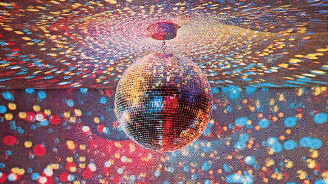 An apparatus that produces a colorful bubble light display covering dark walls and ceiling beneath a large shimmering disco ball, 1960s.